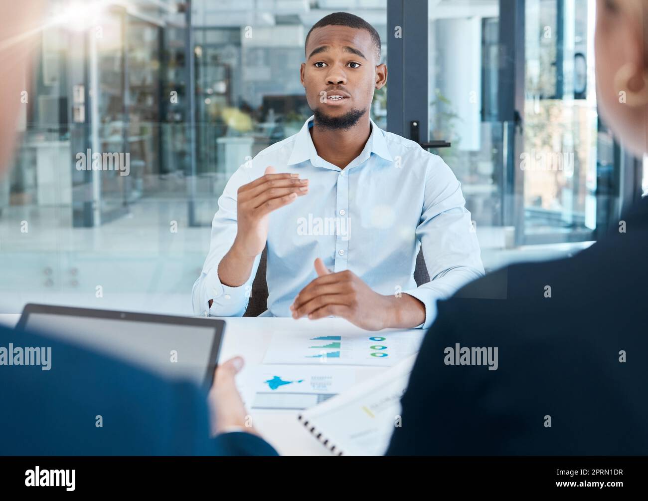 Black man, interview and office presentation to business team on analysis, data and research. African man in corporate discussion explaining company strategy and analytics for innovation and goals Stock Photo