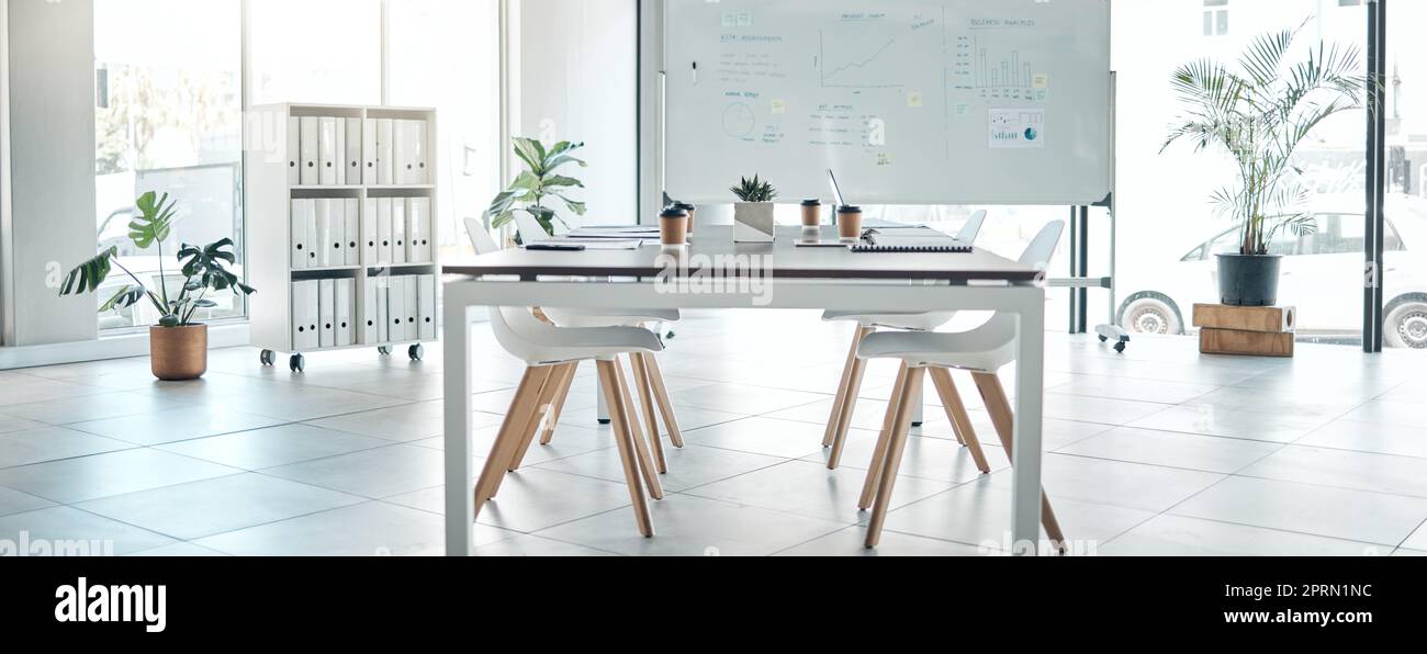 Empty boardroom, conference or meeting room with table, chairs and whiteboard. Business presentation office, corporate company interior space and furniture in modern workplace for discussion. Stock Photo
