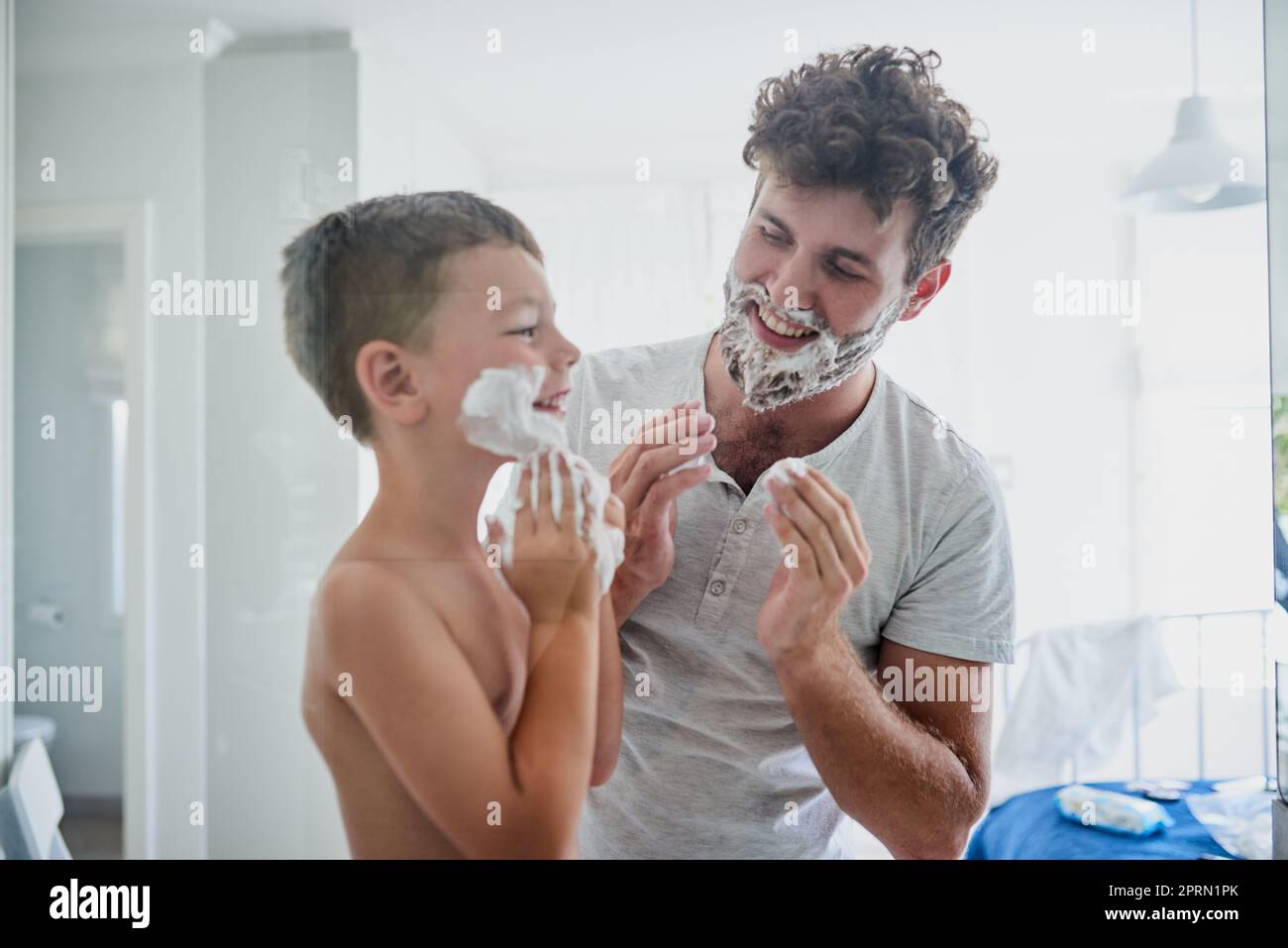 One day youll have a real beard too. a father teaching his little son
