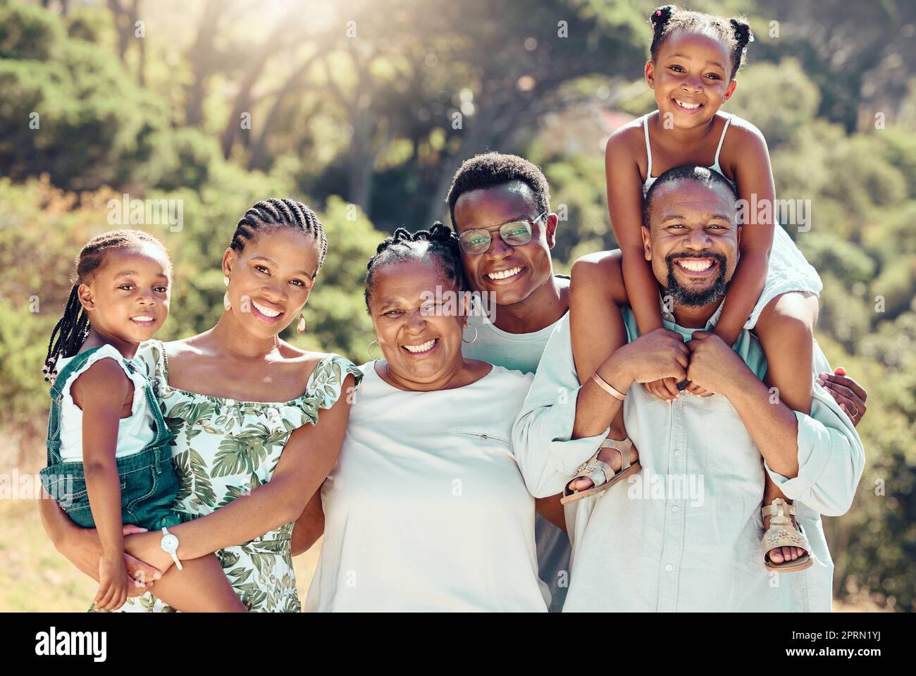 Face portrait of family in nature park, parents in garden with children and senior people with smile on group walk in summer. Smile, happy and African kids in green yard with mother and father Stock Photo