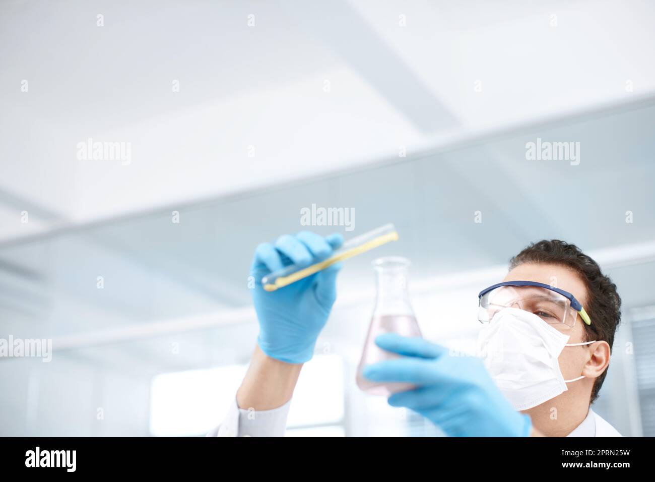 The expert at mixing chemicals. Low angle shot of a chemist mixing chemicals. Stock Photo