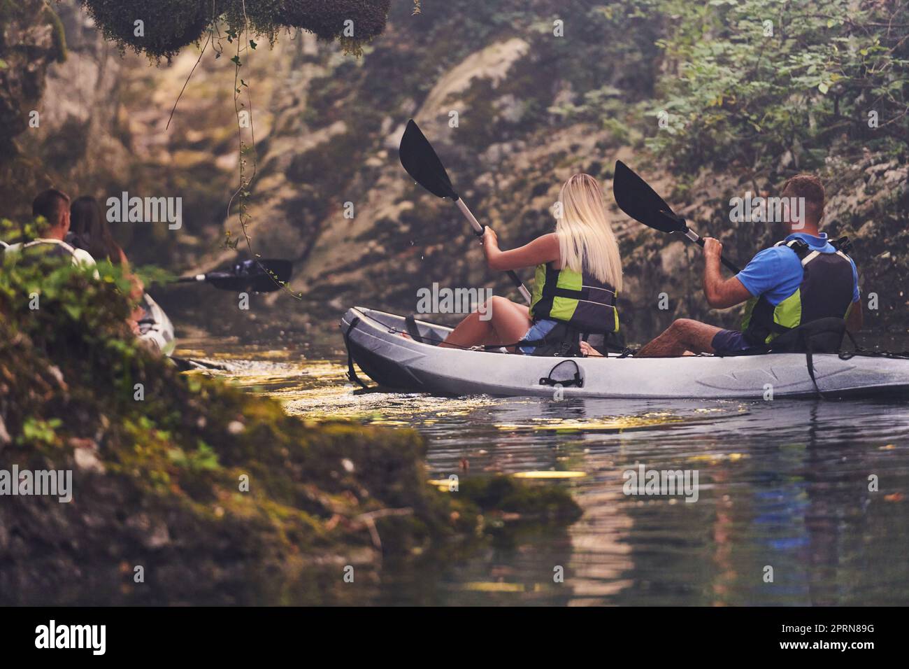 A young couple enjoying an idyllic kayak ride in the middle of a ...