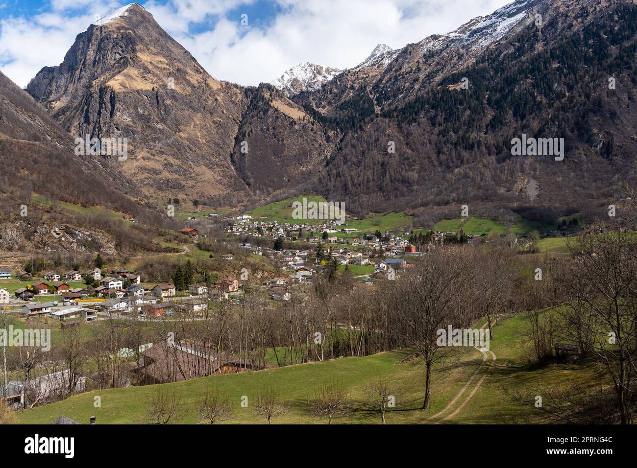 A scenic view of a quaint village nestled in a lush valley surrounded ...