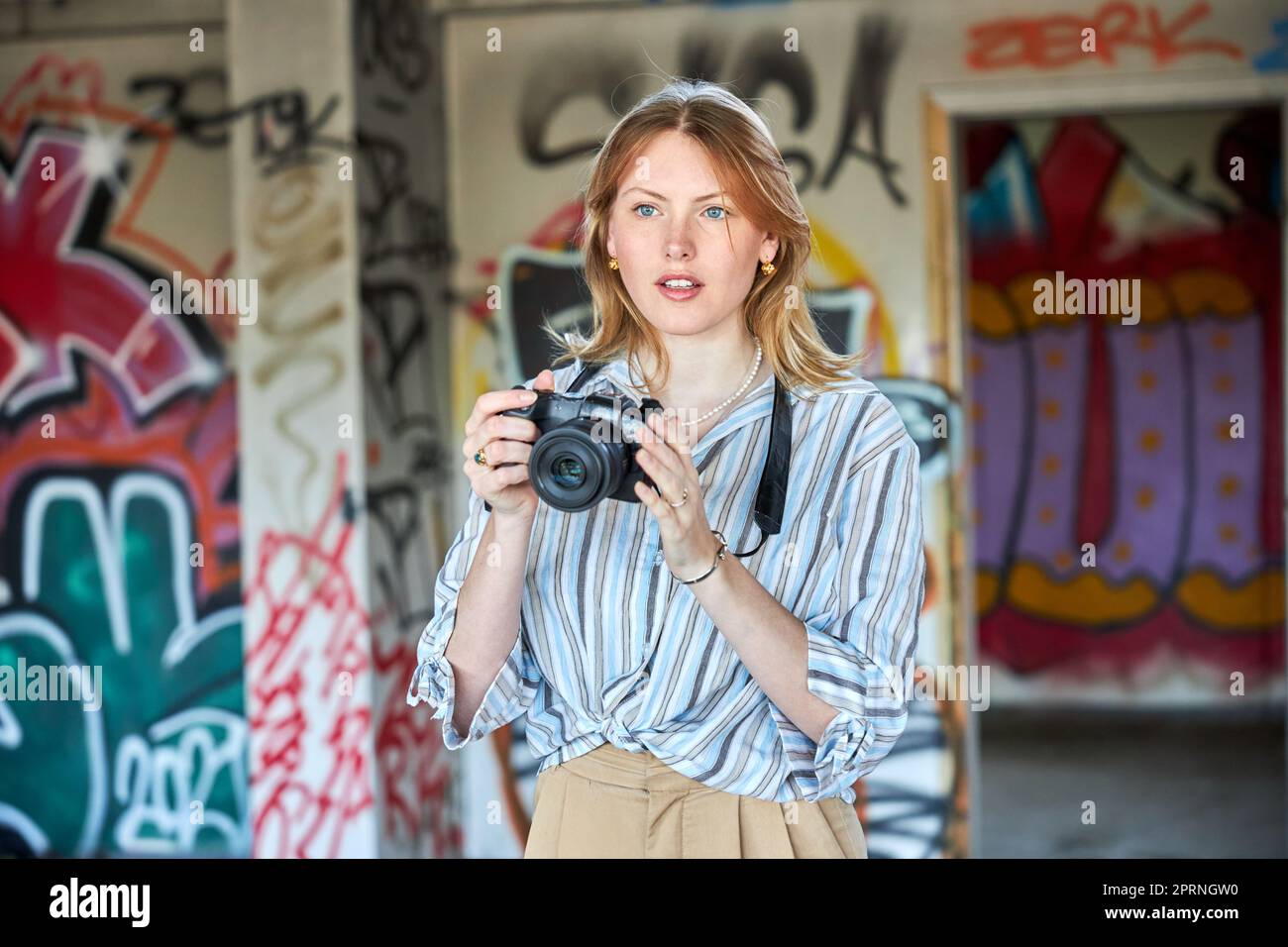 Red hair girl in a building with a camera Stock Photo