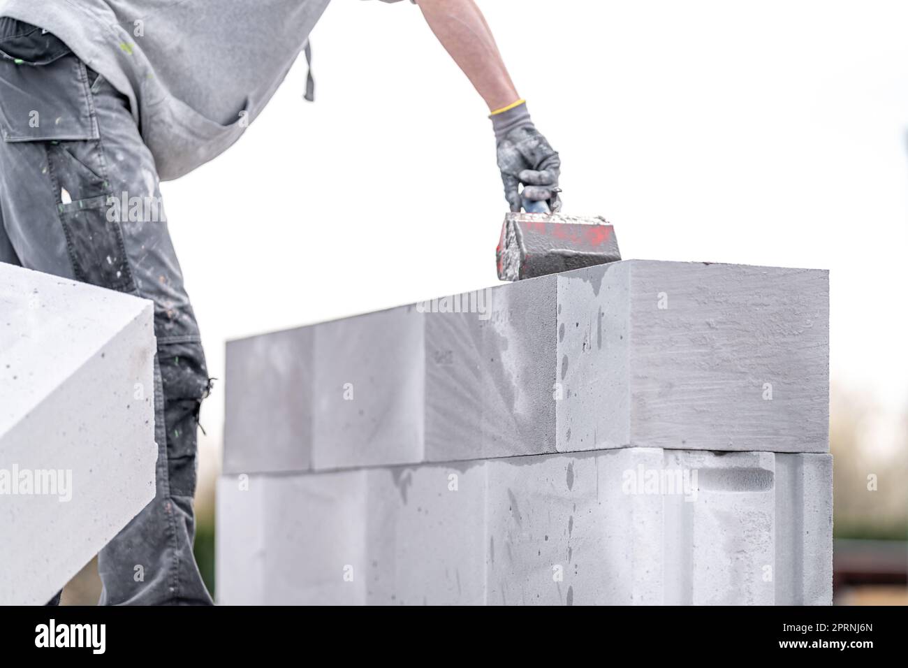 the mason applies glue to the concrete forms. construction of a wall of