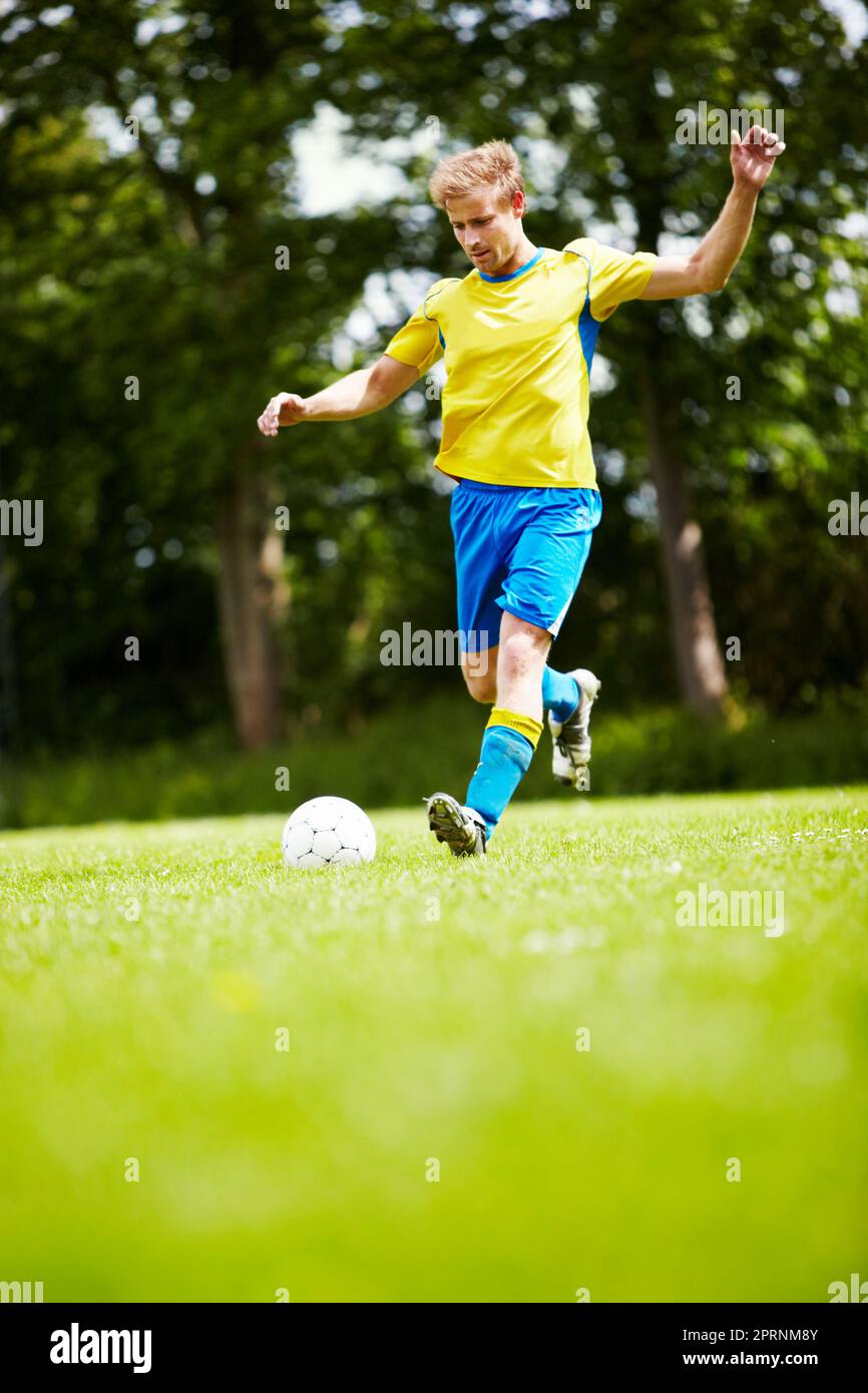 Practising his technique. a soccer player running up to kick the ball with gusto Stock Photo Alamy