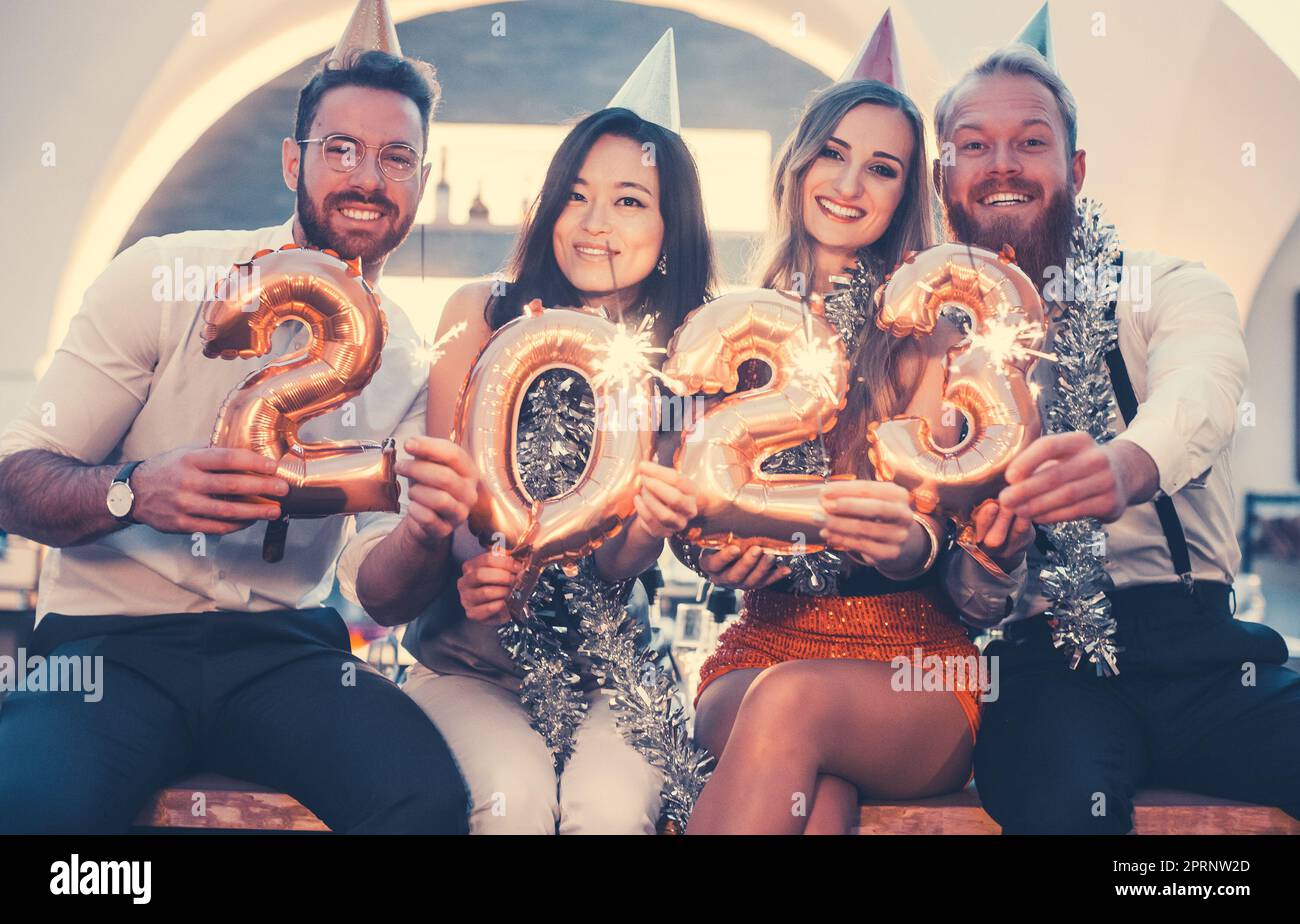 women and men celebrating the new year 2023 with wine Stock Photo