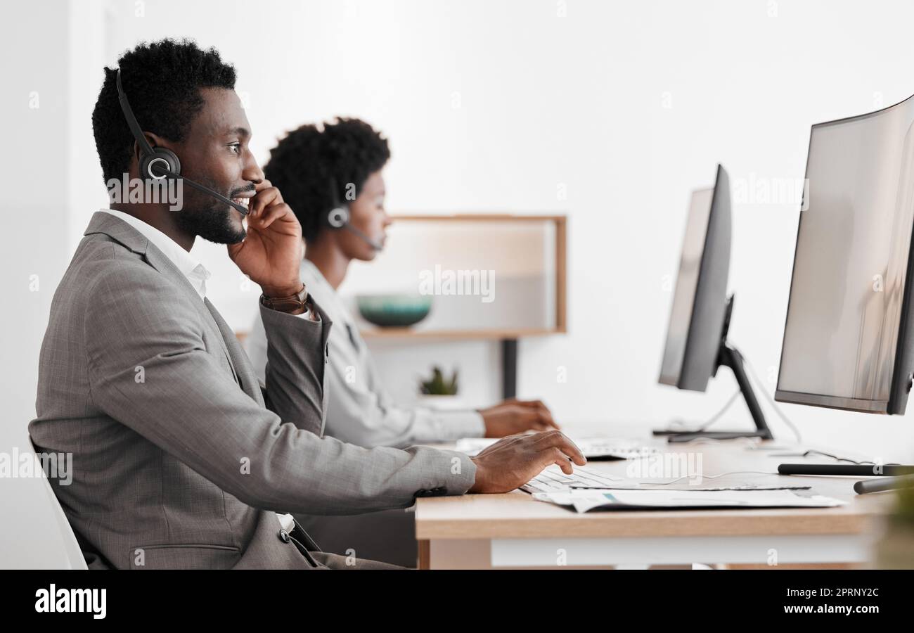 Support, consulting and a black man and woman in call center with headset and computer, help in customer service. Crm, telemarketing and sales for corporate communication employee talking on phone. Stock Photo