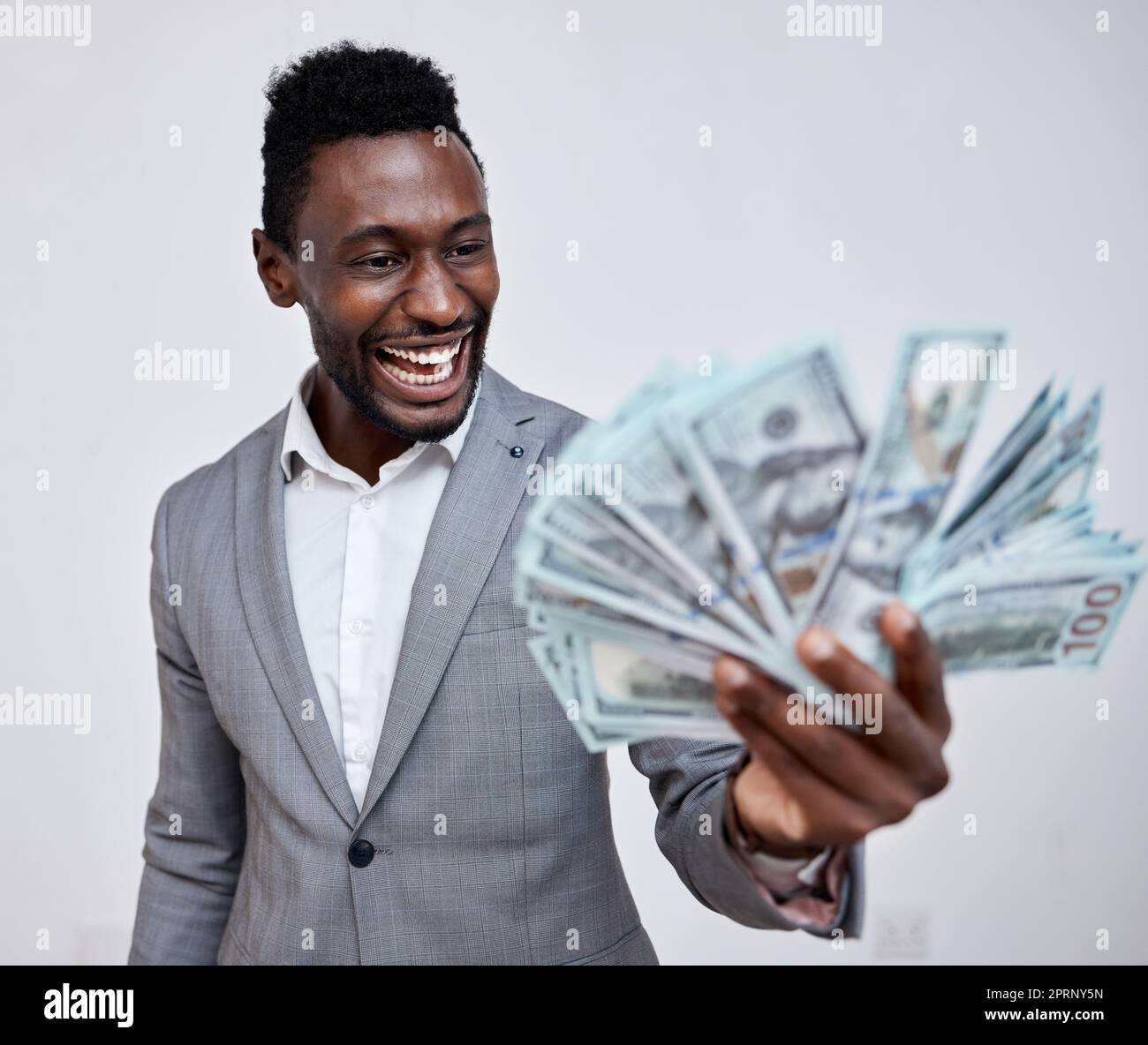 Happy black man with dollars, money or winner isolated on a grey mockup background. Finance, wealth and excited rich African person with a stack of bills, lotto or financial investment business deal Stock Photo