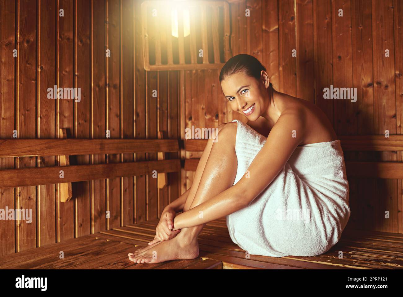 Surrendering to serenity. Full length portrait of a young woman relaxing in the sauna at a spa. Stock Photo