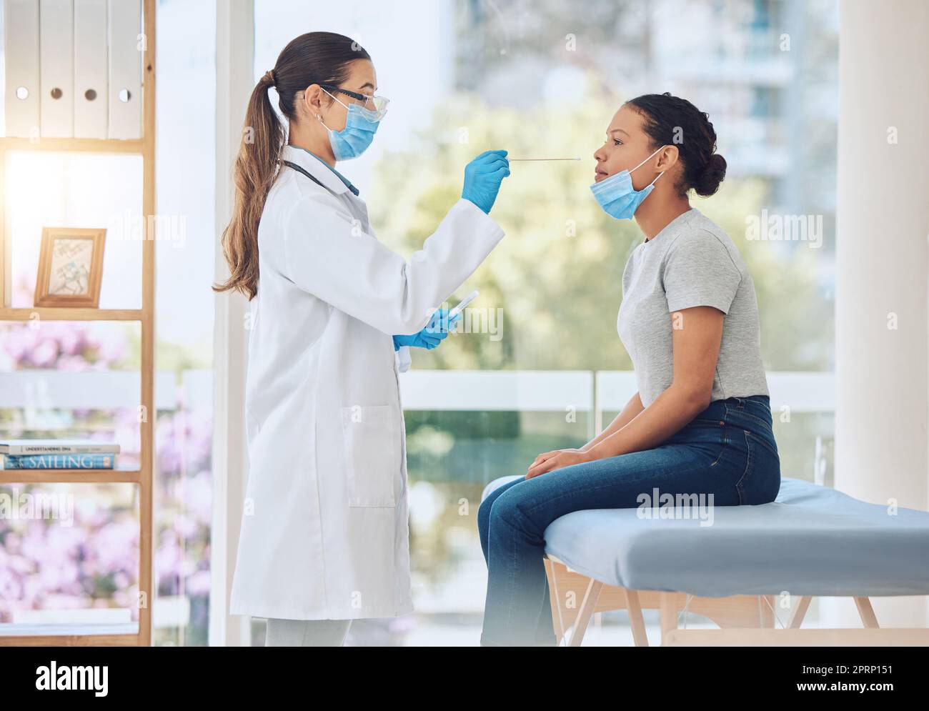 Doctor, covid nose test and woman in hospital for healthcare compliance, insurance policy routine and medicine research. Medical worker, trust and consulting employee with sick patient and face mask Stock Photo