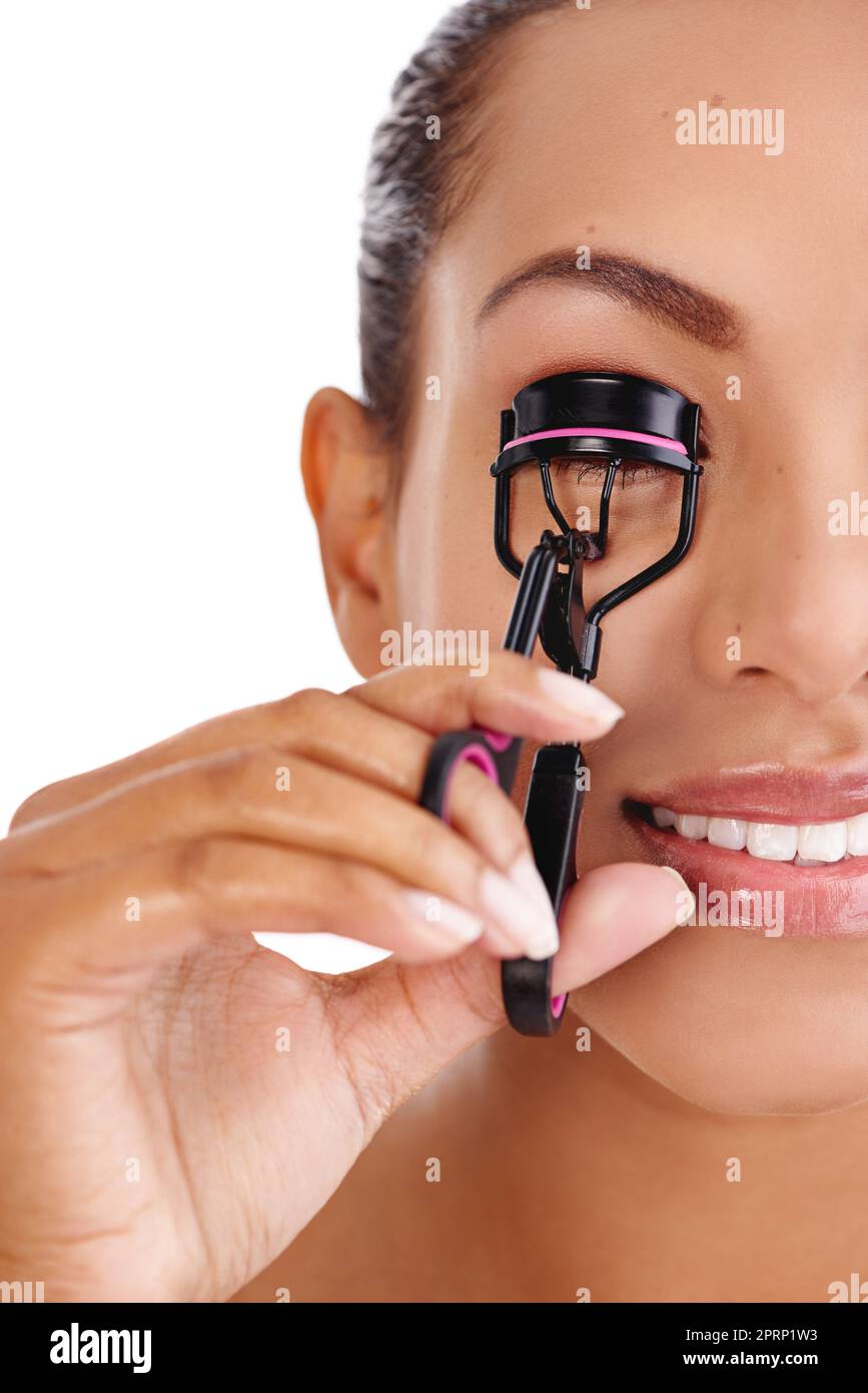 Making her eyelashes look longer, fuller, thicker. Studio shot of a beautiful young woman using an eyelash curler. Stock Photo