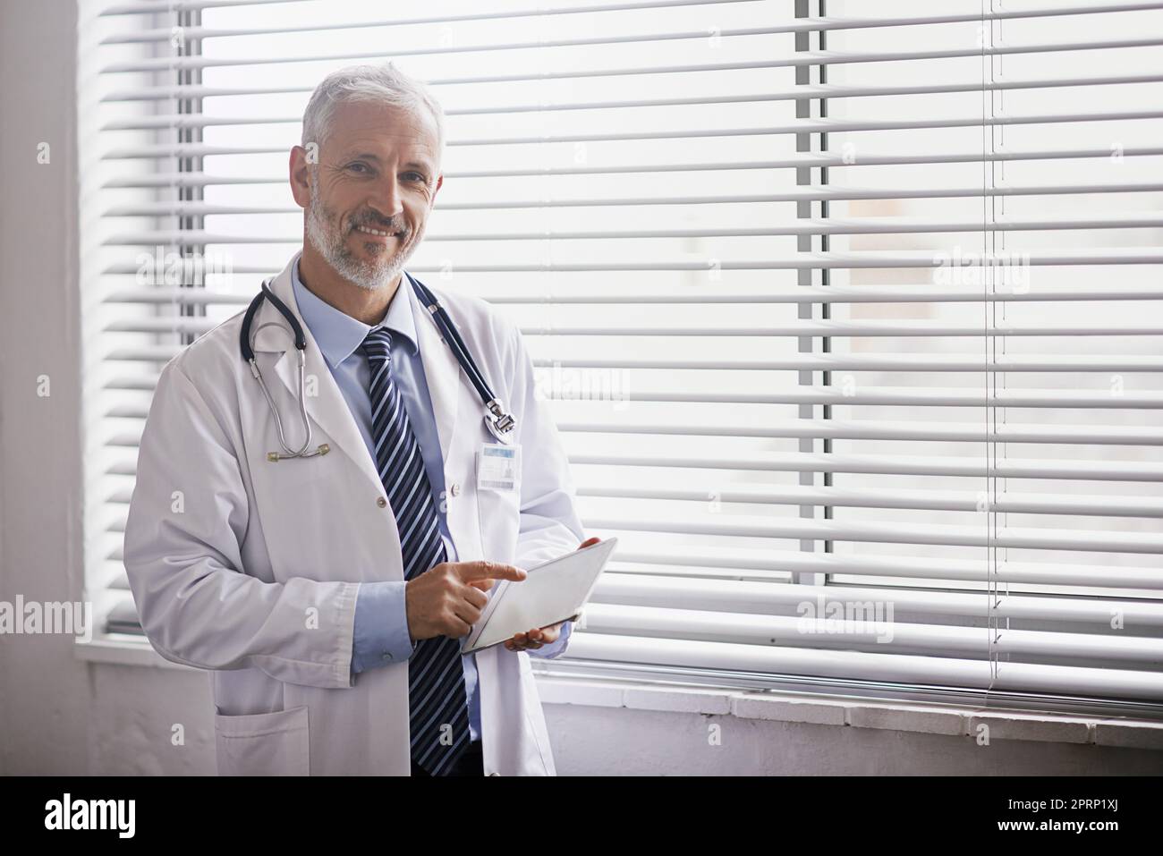 Making good use of technology in his practice. Portrait of a mature male doctor using a digital tablet. Stock Photo
