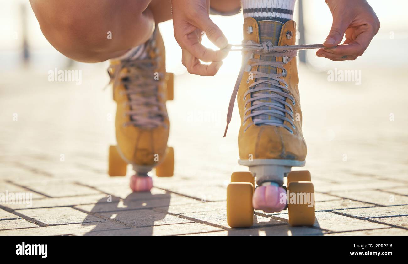 Yellow roller skates shoes of woman in summer outdoor travel, journey or fun activity for the holiday. Cool, trendy or funky gen z person prepare or tie laces on ground in quad skating with sunshine Stock Photo
