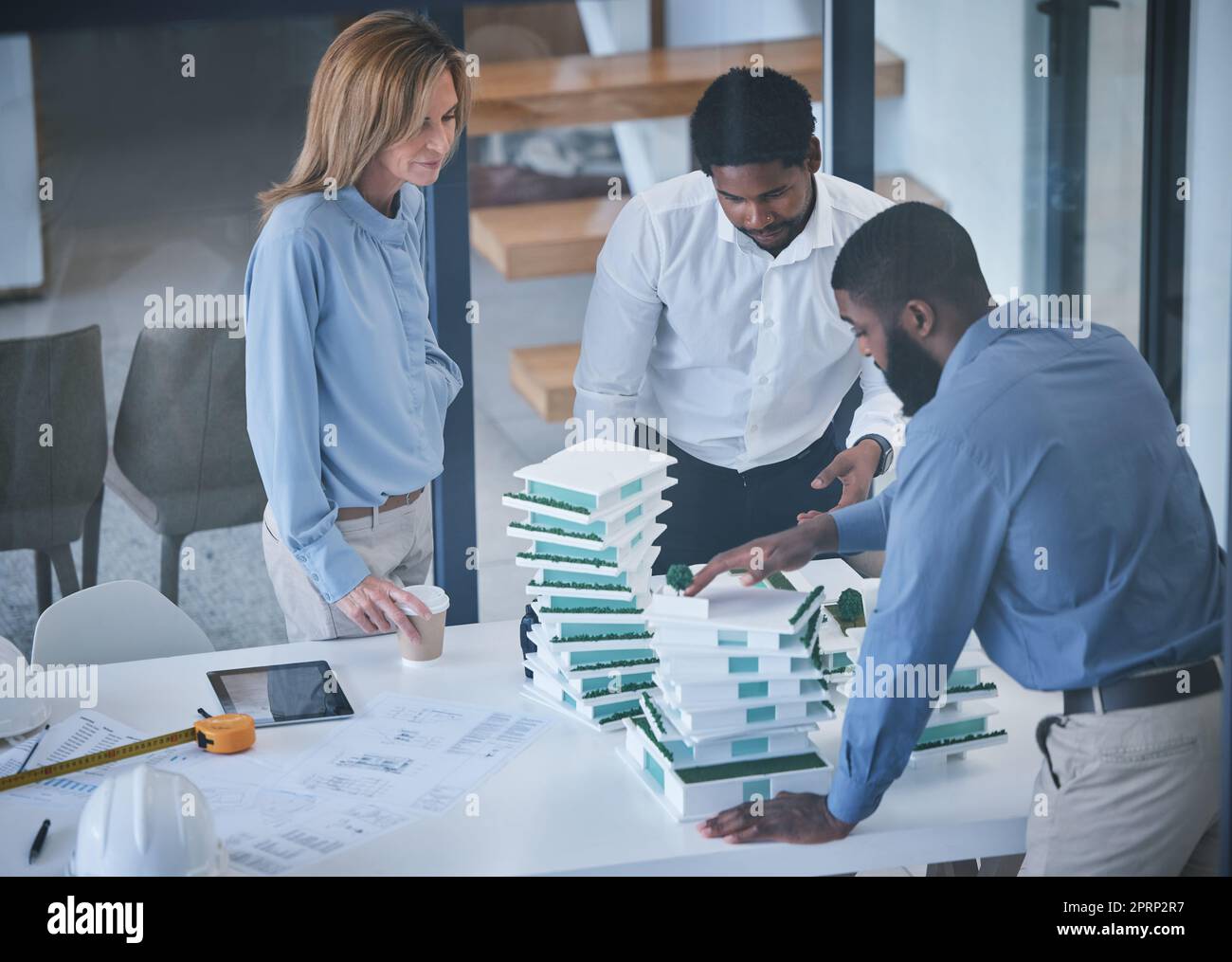Architecture, collaboration and planning with an architect, engineer and builder meeting and discussing 3d building design or model. Teamwork and design by men and woman planning construction project Stock Photo
