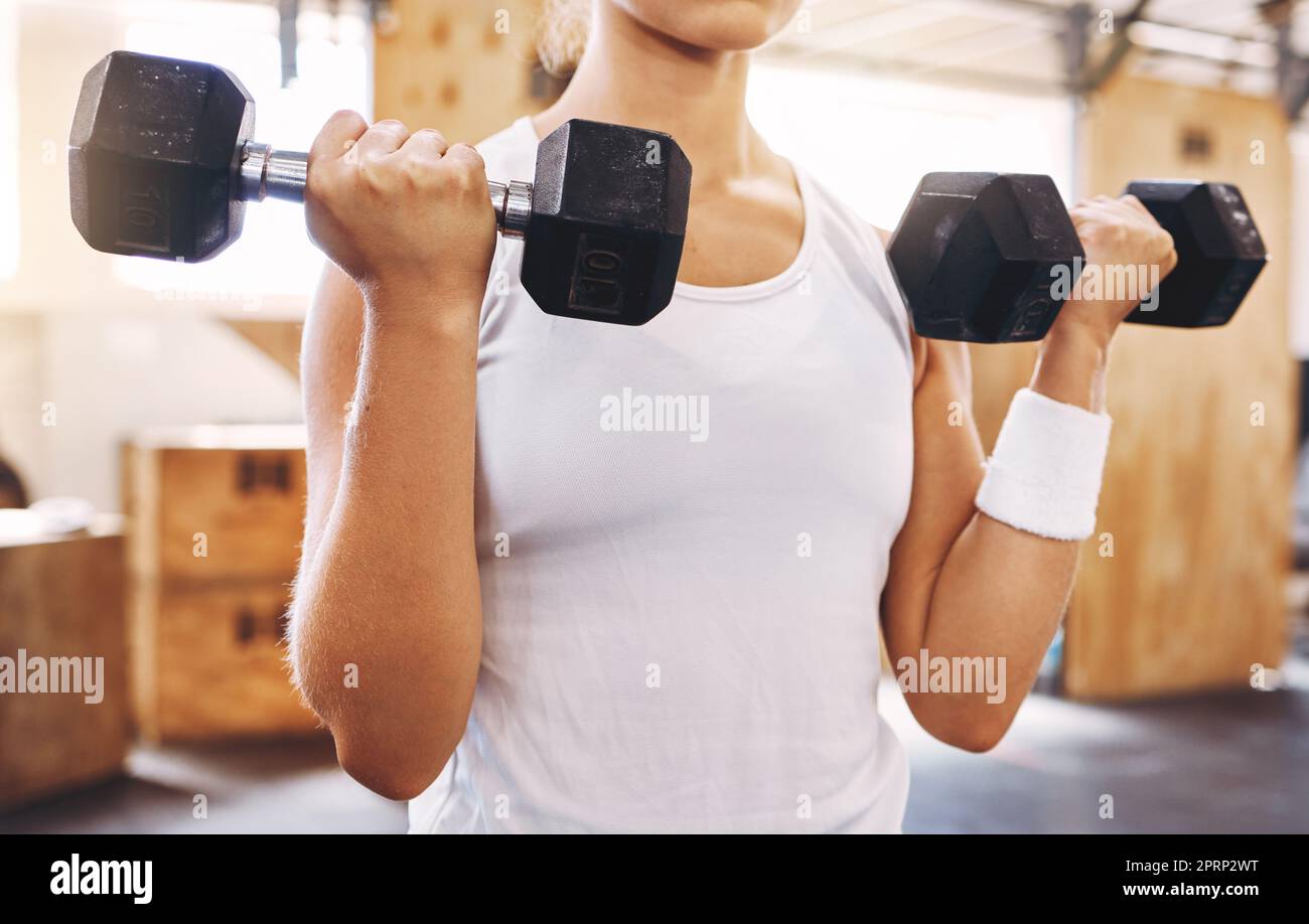 Hands of woman, dumbbell and exercise or workout at the gym for fitness and health. Healthy, sport and sports trainer or athlete or gymnast training for muscle power and weight lifting competition Stock Photo