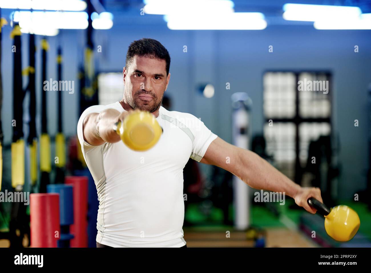 Work out like a winner. a man working out with kettle bells at the gym. Stock Photo