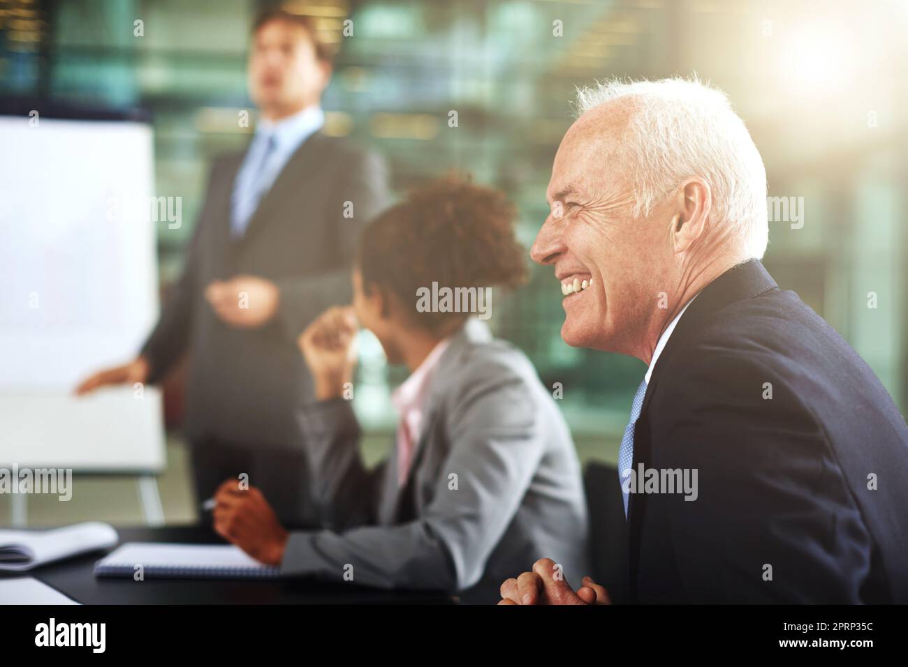 He couldnt be happier. a group of businesspeople listening to a presentation. Stock Photo