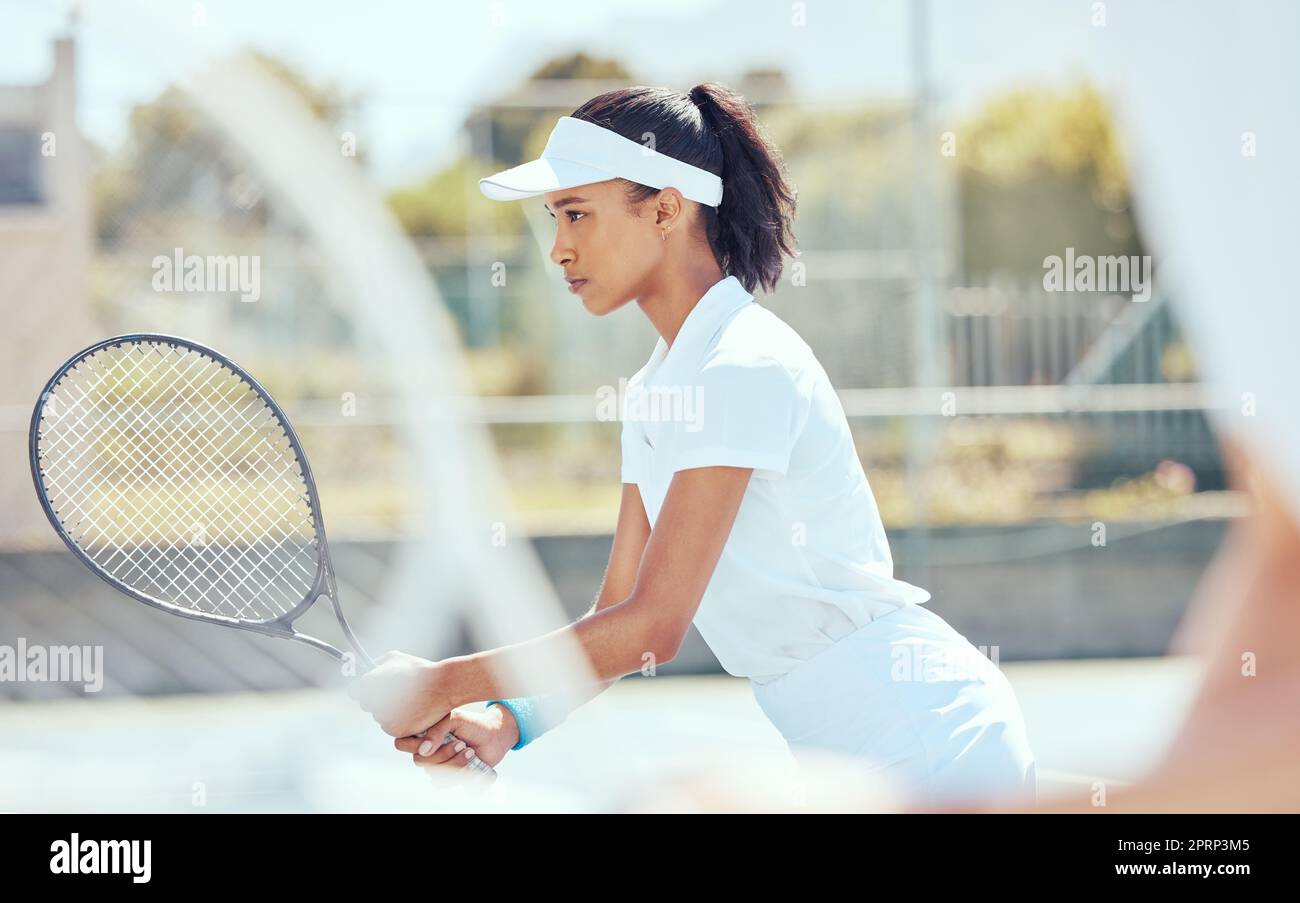 Tennis, sport and exercise with a sports woman playing a game or match on a court outside. Fitness, training and workout with a young female athlete ready for health and recreation with focus Stock Photo