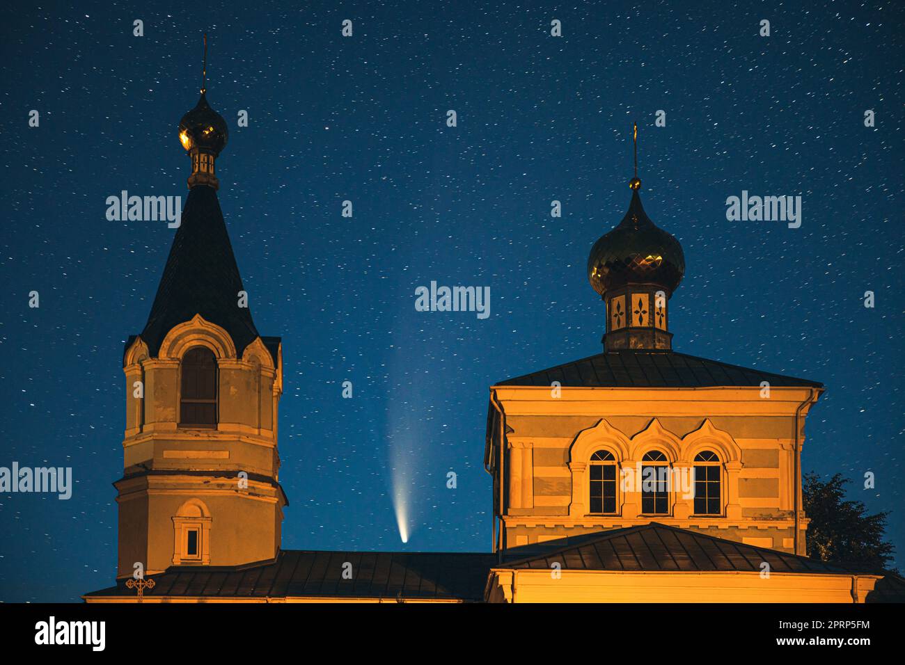 Korma Village, Dobrush District, Belarus. Comet Neowise C2020f3 In Night Starry Sky Above St. John The Korma Convent Church In Korma Village. Famous Orthodox Church And Historic Heritage Stock Photo