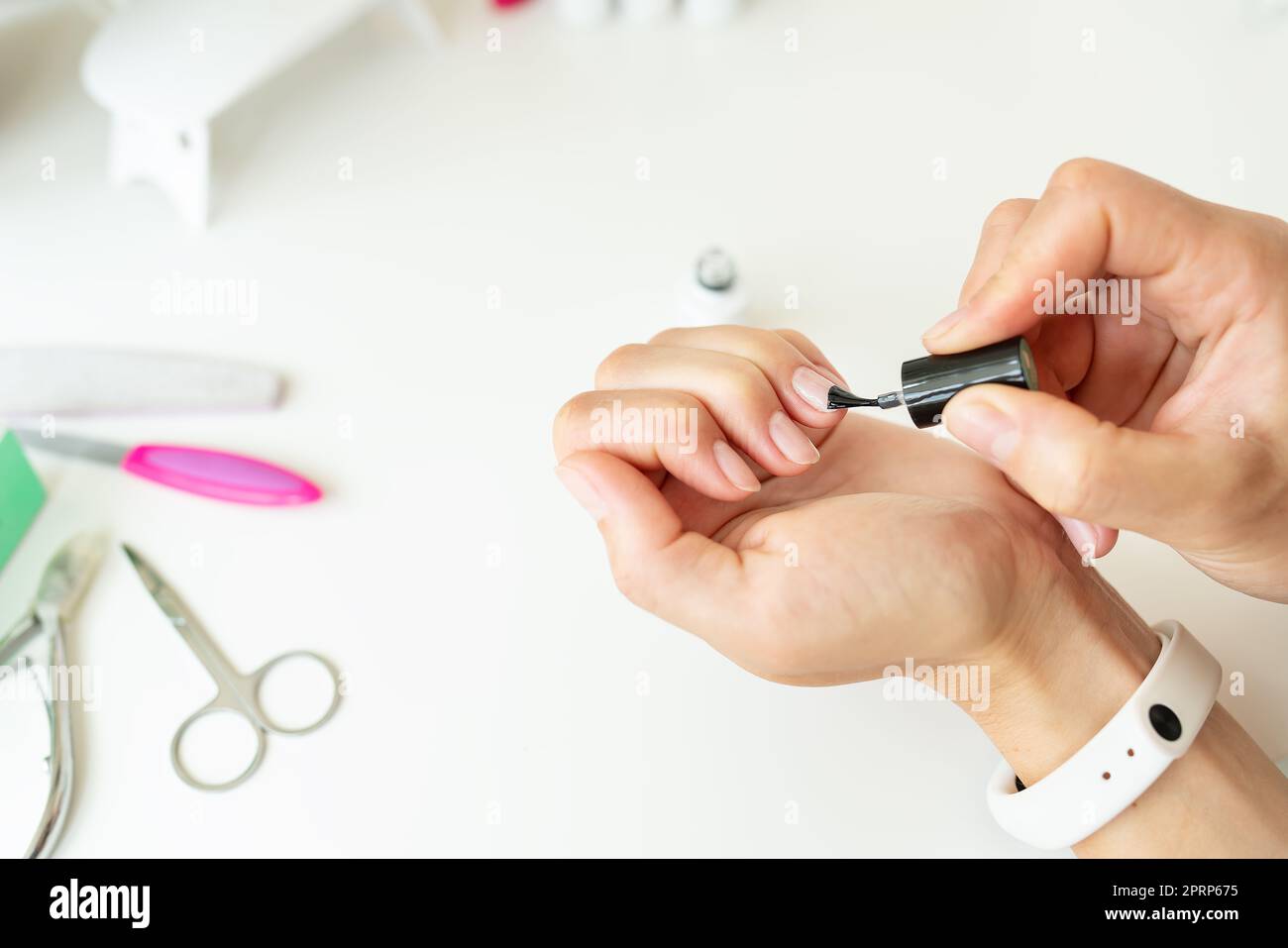 Covering nails with gel polish in a beauty salon or at home, your own master. Professional hand care. Stock Photo