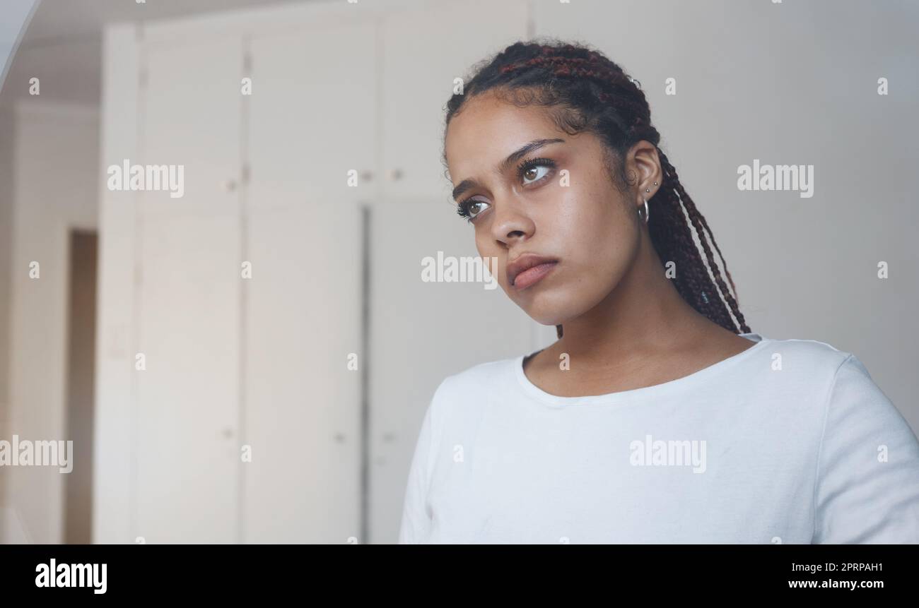 Sad, thoughtful and depressed woman in her home feeling alone and isolated. Mock up for depression, sadness and mental health issues. Thinking, worrie Stock Photo