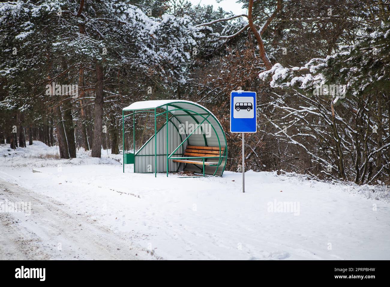 Bus stop in the middle of a beautiful winter road in the middle of the ...