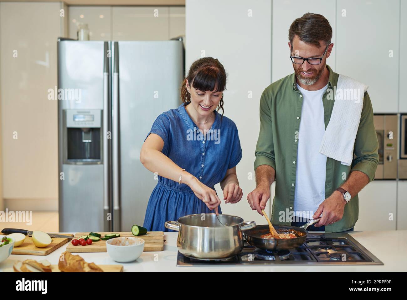 Its going to be twice as tasty. a mature couple cooking together at home Stock Photo