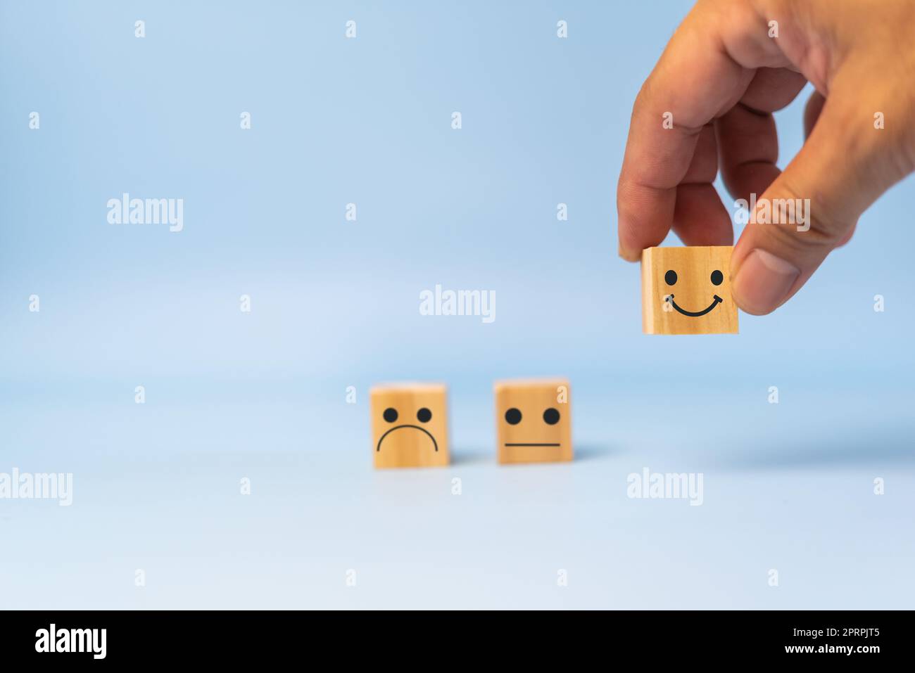Customer service and Satisfaction concept happy Smiley face icon.Business feedback positive rating very impressed wood cube on table. Stock Photo