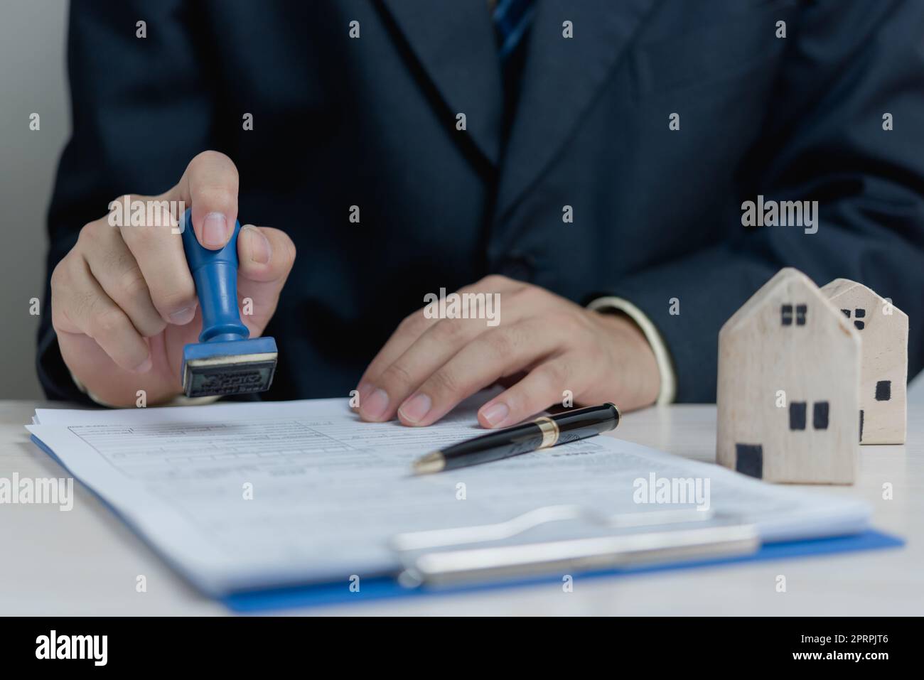 Buying and selling real estate or borrowing money, bank loans, approved investments.Businessman rubber stamp document on desk. Stock Photo