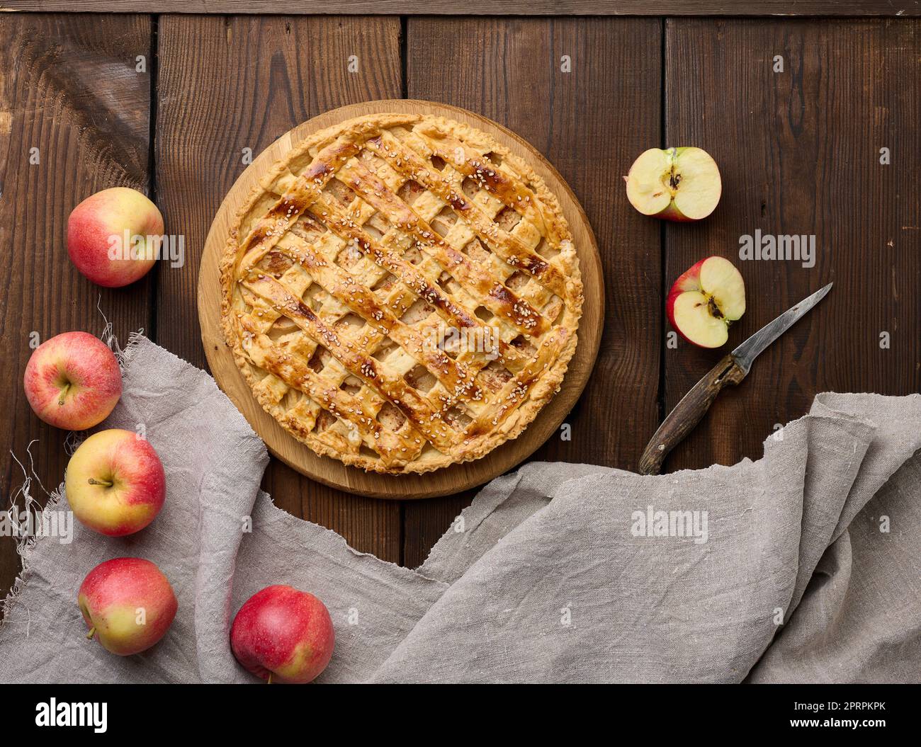 Round baked apple pie on a brown wooden table, top view Stock Photo
