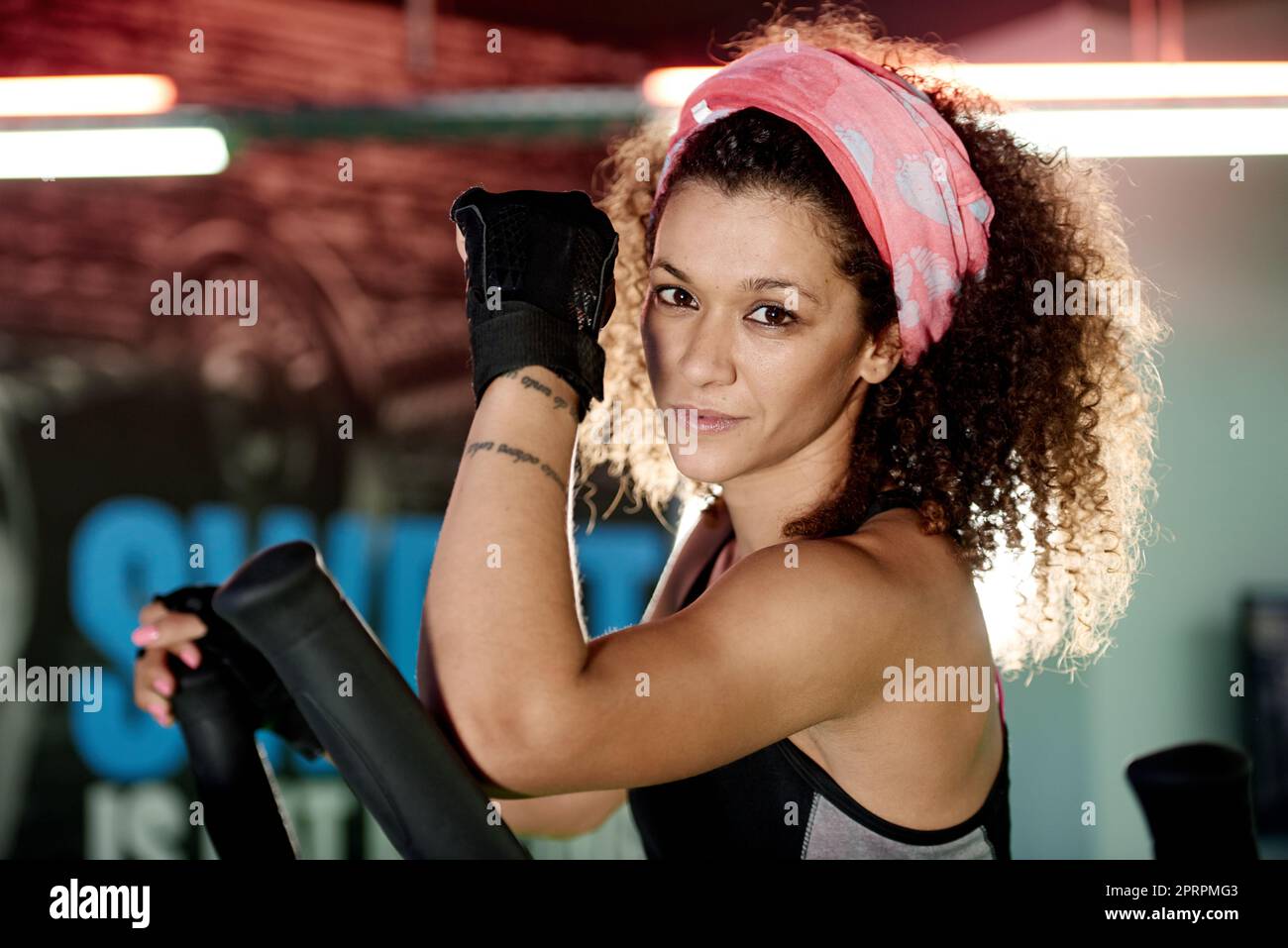 Look like a beauty train like a beast. a young woman working out with a stepping machine at the gym. Stock Photo