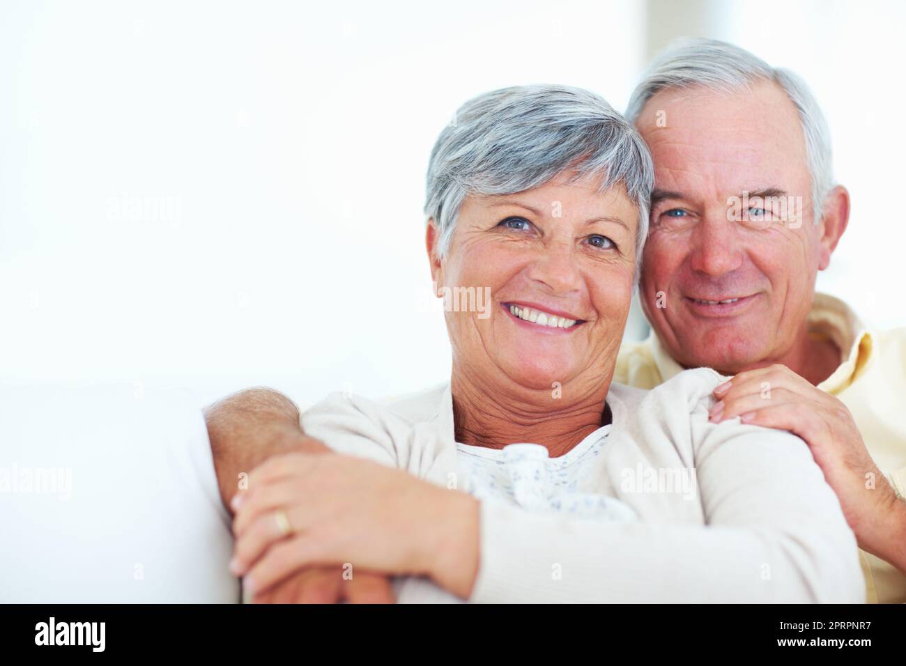 Sheer joy. Closeup of cheerful mature couple laughing together while sitting at home. Stock Photo