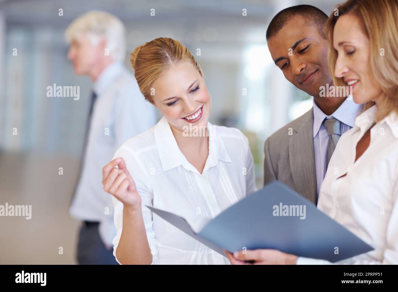 Executive discussing while looking at documents. Portrait of happy multi ethnic executives discussing while looking at documents. Stock Photo