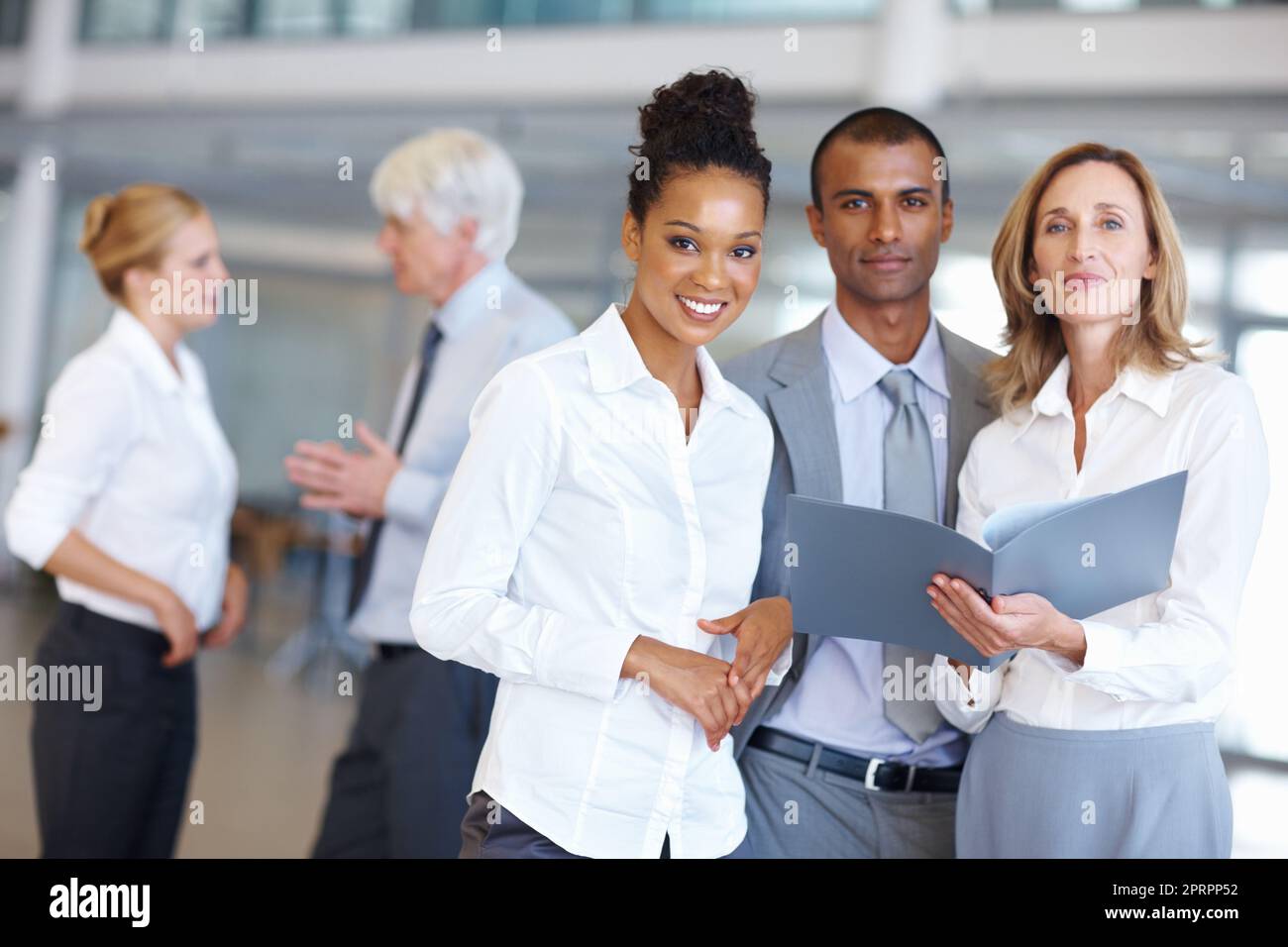 Smiling executives with documents. Portrait of multi ethnic executives with documents at office. Stock Photo