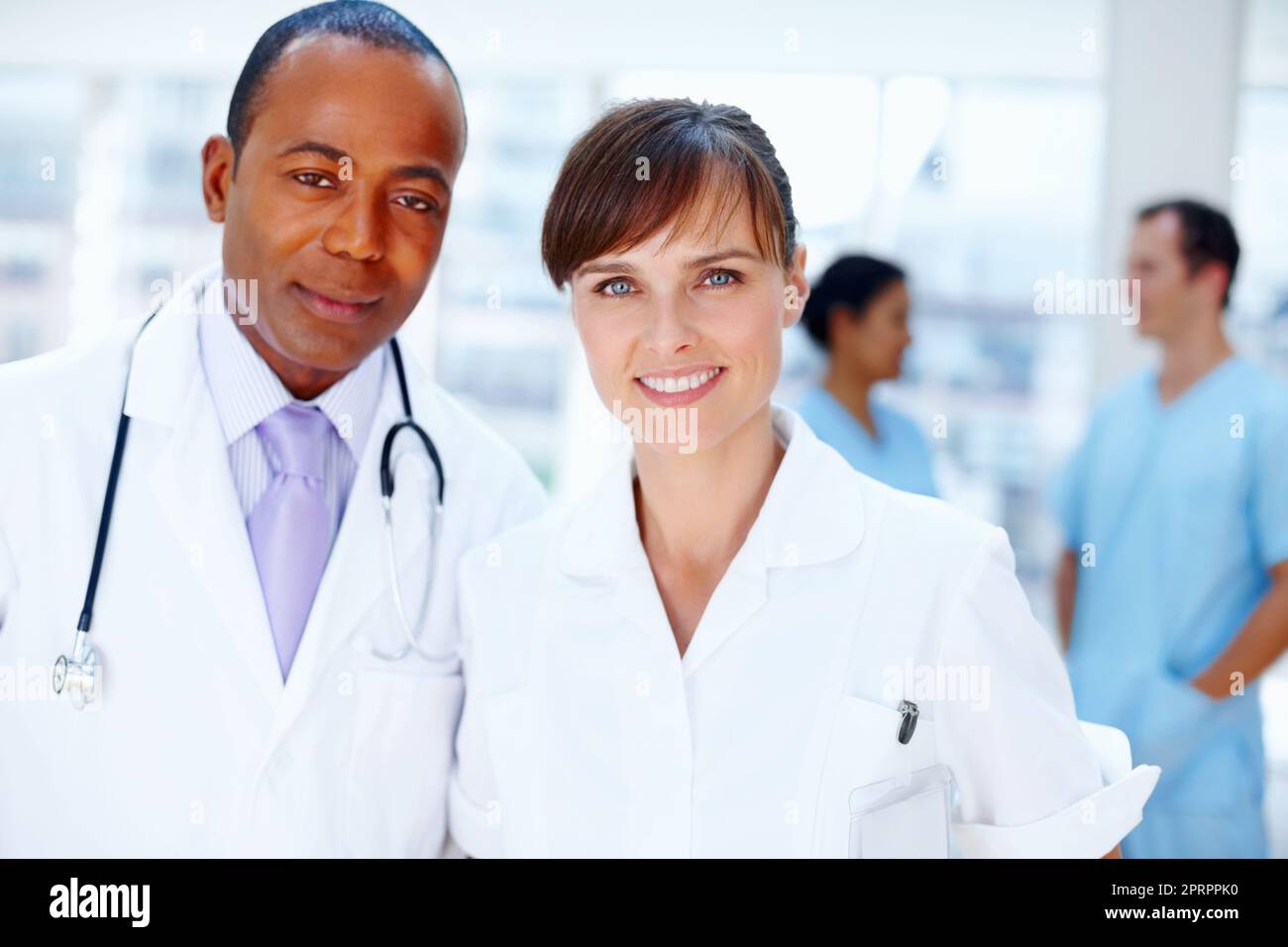 Healthcare professionals. Closeup of doctors with nurses in background. Stock Photo