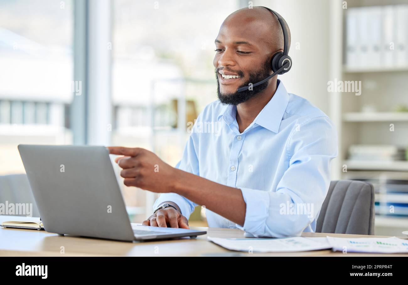 Call center, black man on laptop and video call with headset consulting, customer service or support. African sales man, crm telemarketing or contact us, work or consultant operator at the office. Stock Photo