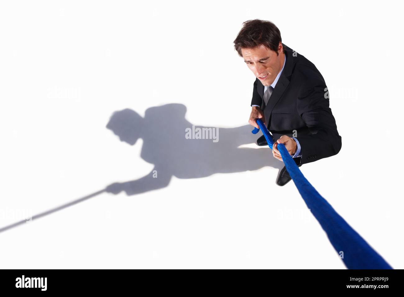 A young business man pulling a rope isolated on white. A young business man pulling a rope isolated on white background. Stock Photo