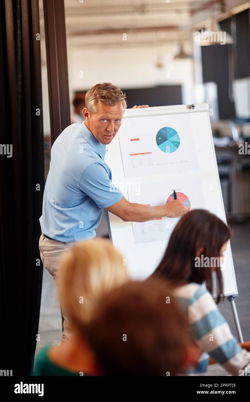 Pointing out their progress. a mature man doing a presentation for his colleagues. Stock Photo