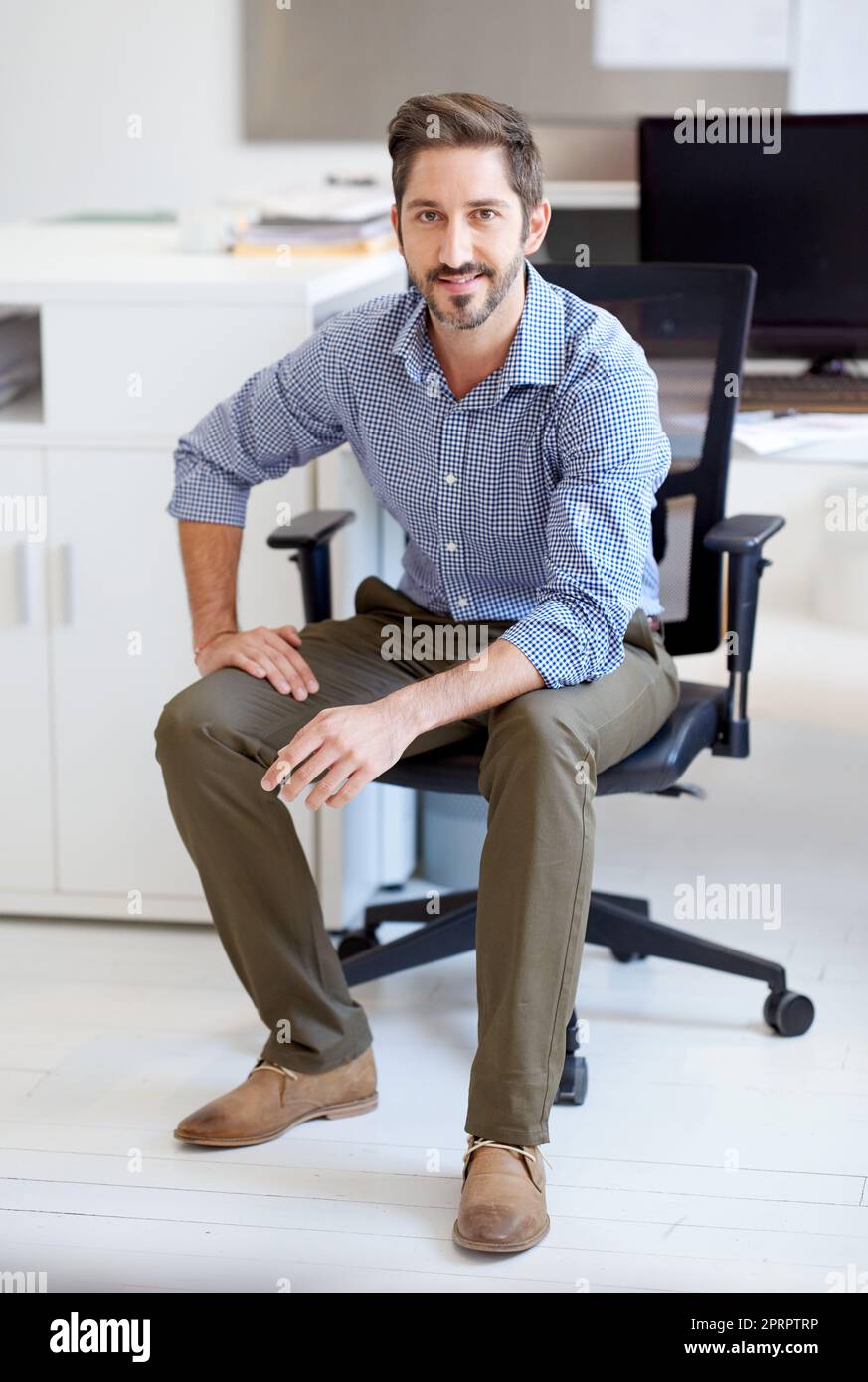 Youre looking at of the best in the biz. Portrait of a young designer sitting at his workstation in an office. Stock Photo