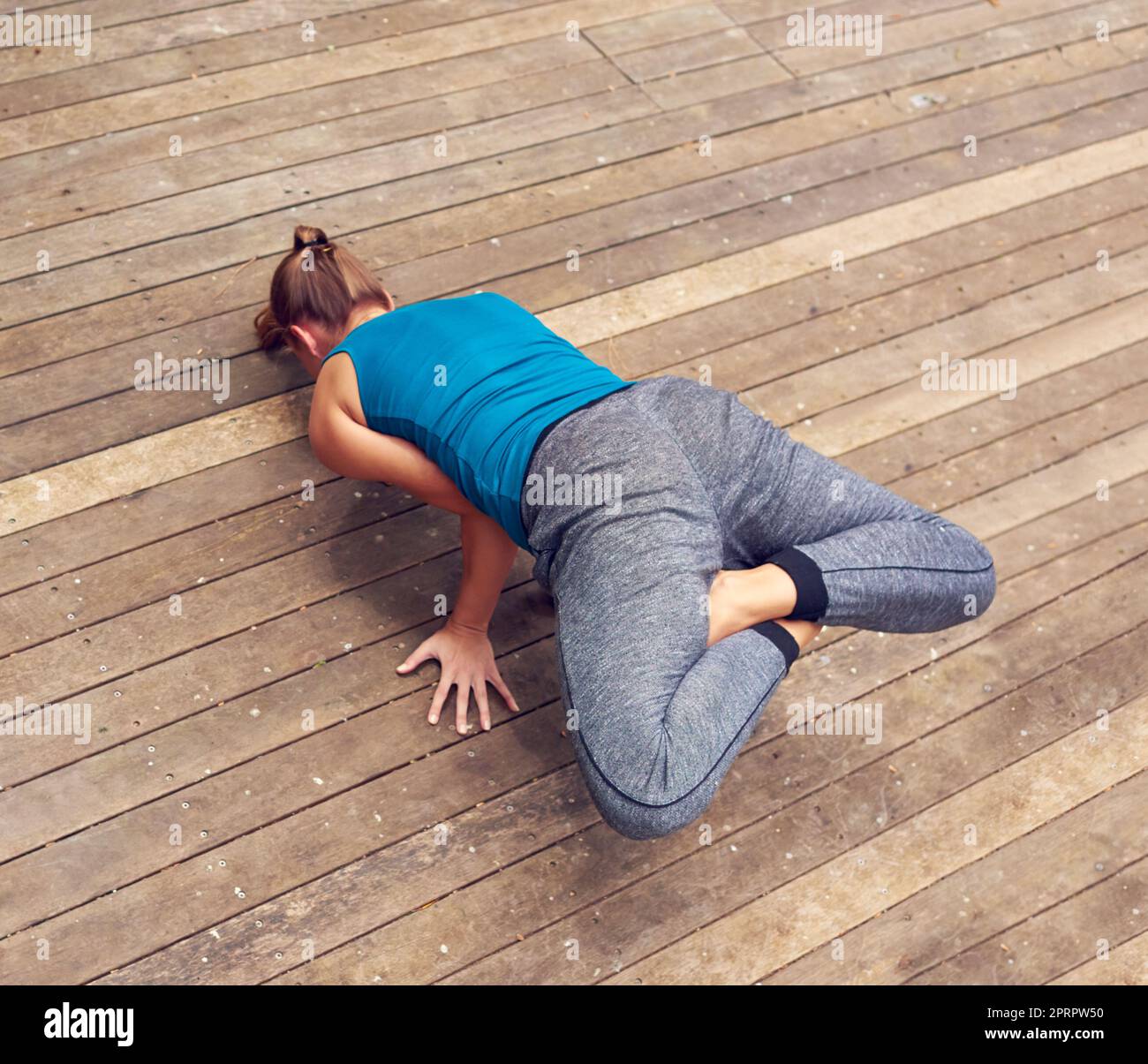 Perfecting the peacock pose. a young woman practicing yoga outdoors. Stock Photo
