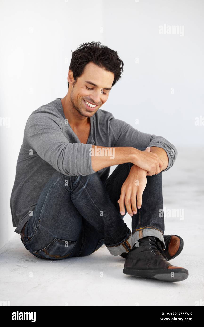 Hes got a carefree attitude. A handsome young man sitting crossed