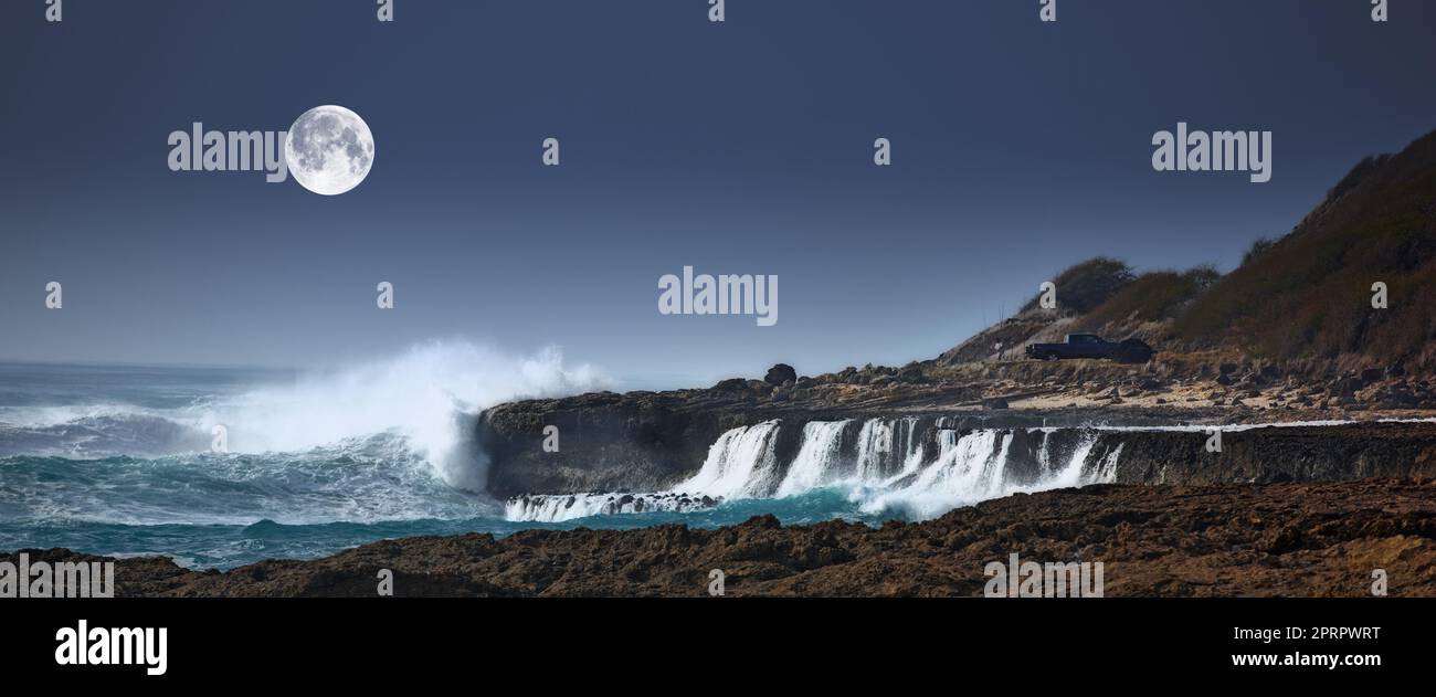 The moon over coast and big waves. A photo of the moon over stormy ocean coast. Stock Photo