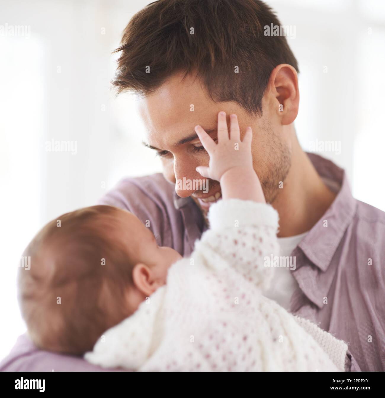 Tender touch. an adorable baby girl touching her fathers face Stock