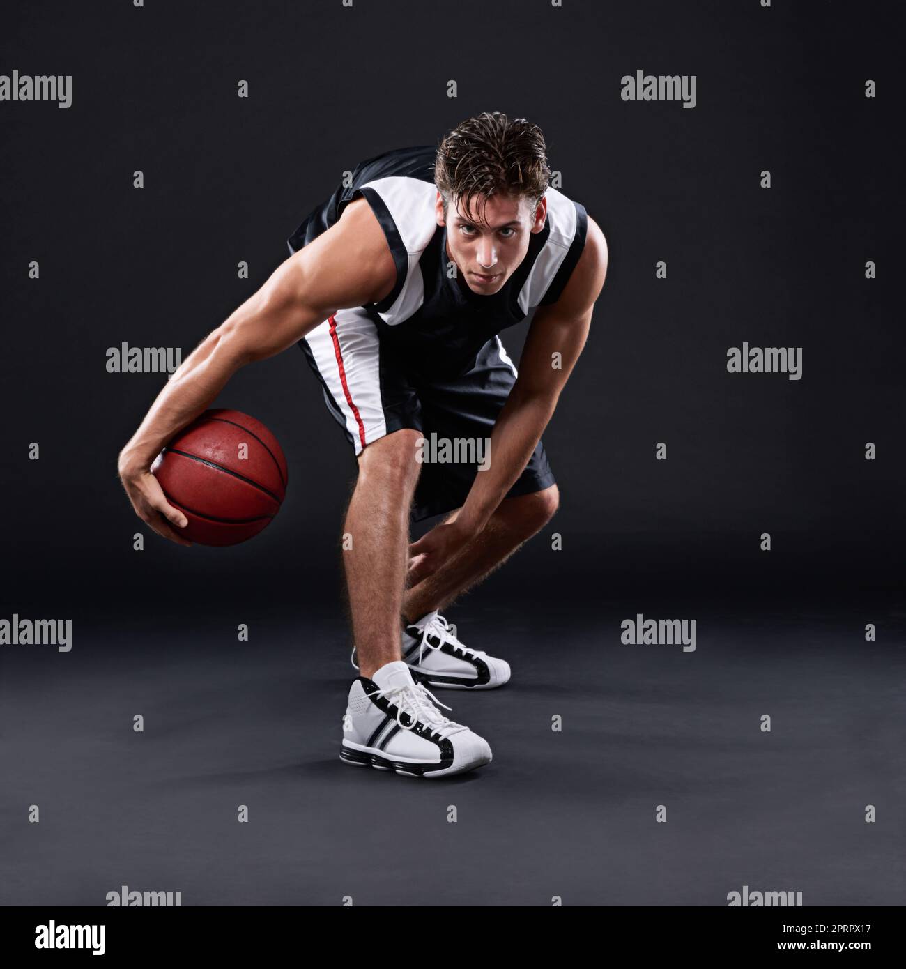 Staying in top form. Full length portrait of a male basketball player in action against a black background. Stock Photo