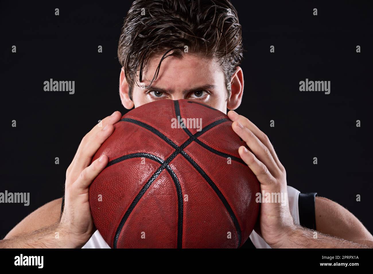 Time to play ball. Cropped studio portrait of a determined basketball player holding the ball out in front of him. Stock Photo
