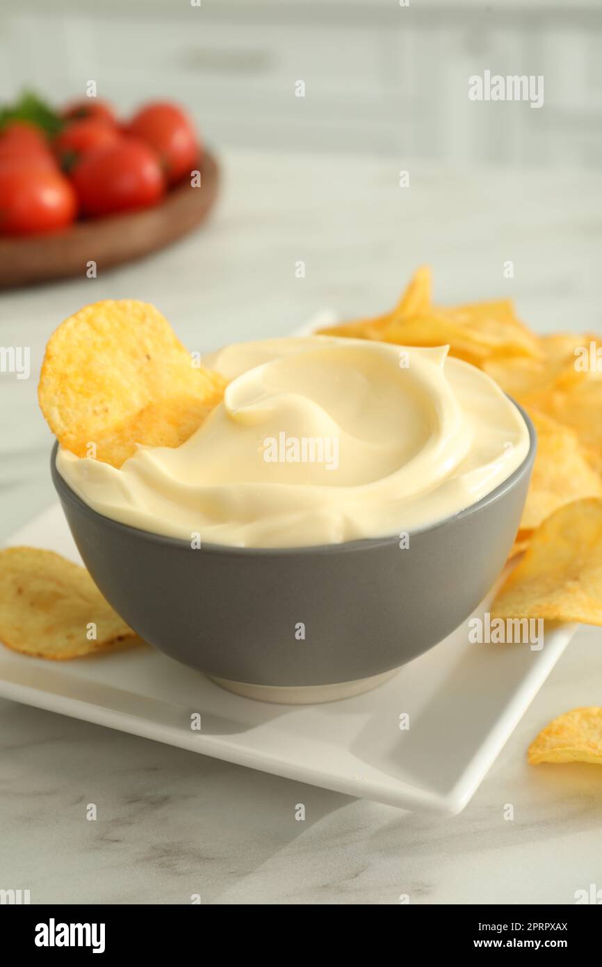 Potato chips and mayonnaise on white marble table Stock Photo - Alamy