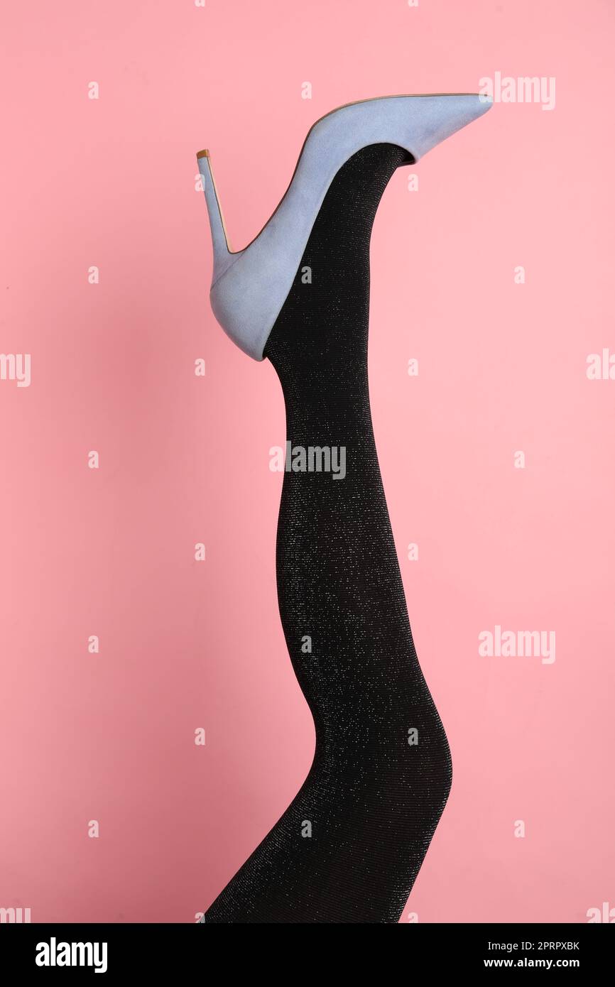 Woman wearing black tights and high heel shoe on pink background, closeup Stock Photo