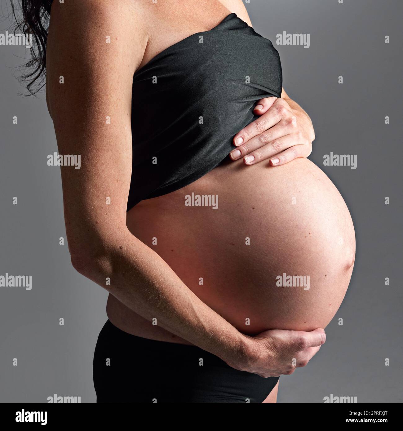Expecting her arrival soon. A pregnant woman holding her tummy. Stock Photo