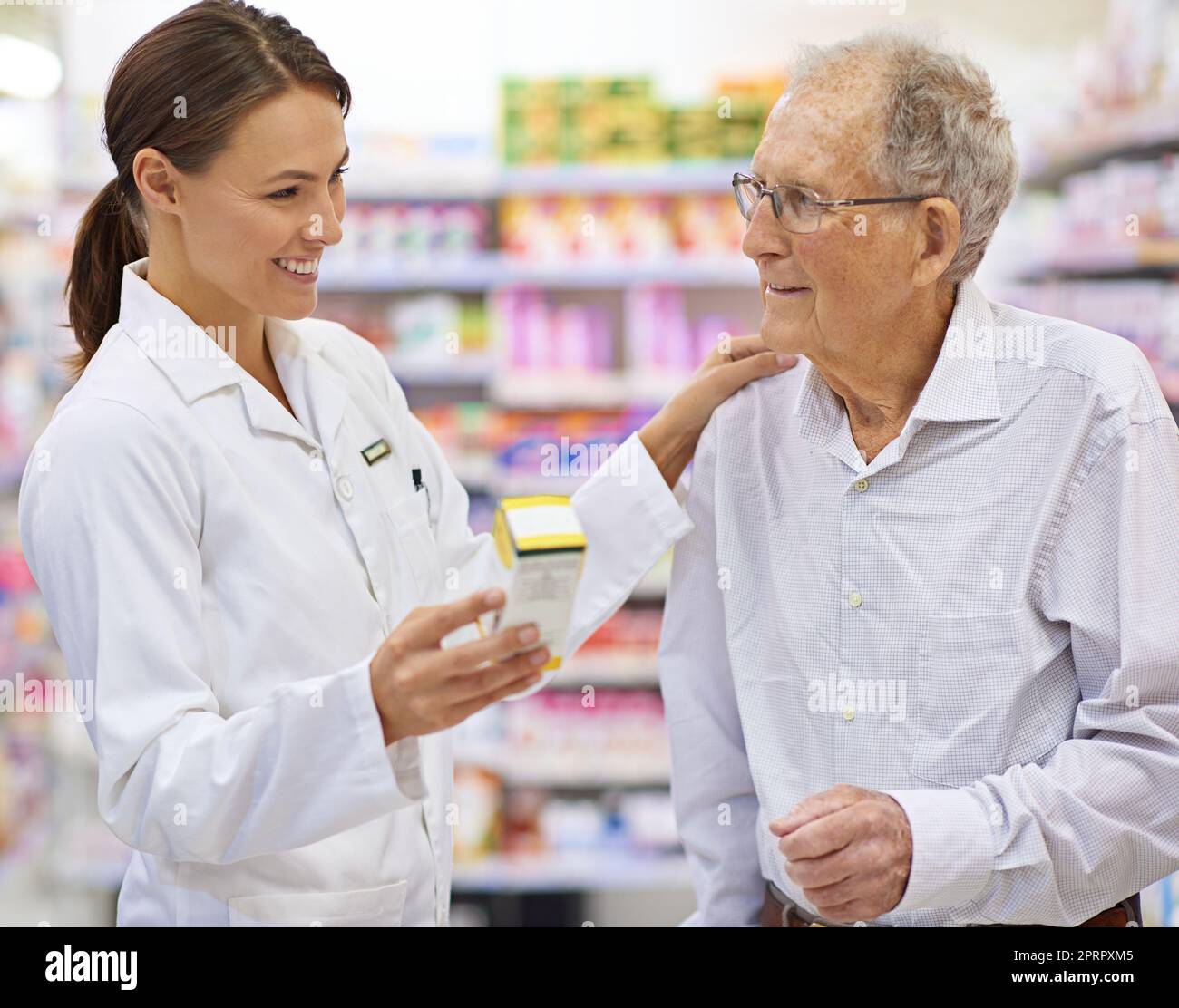 Finding the perfect remedy. a young pharmacist helping an elderly customer. Stock Photo